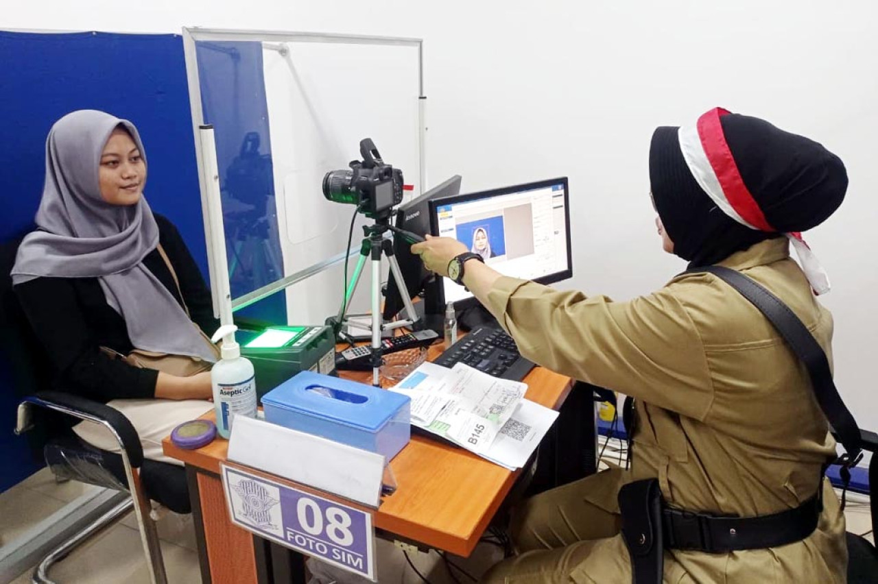 Petugas pelayanan mengenakan kostum pejuang dan veteran saat melayani masyarakat yang mengurus Surat Izin Mengemudi (SIM), Satpas SIM Colombo Surabaya. Foto/JatimNow.com