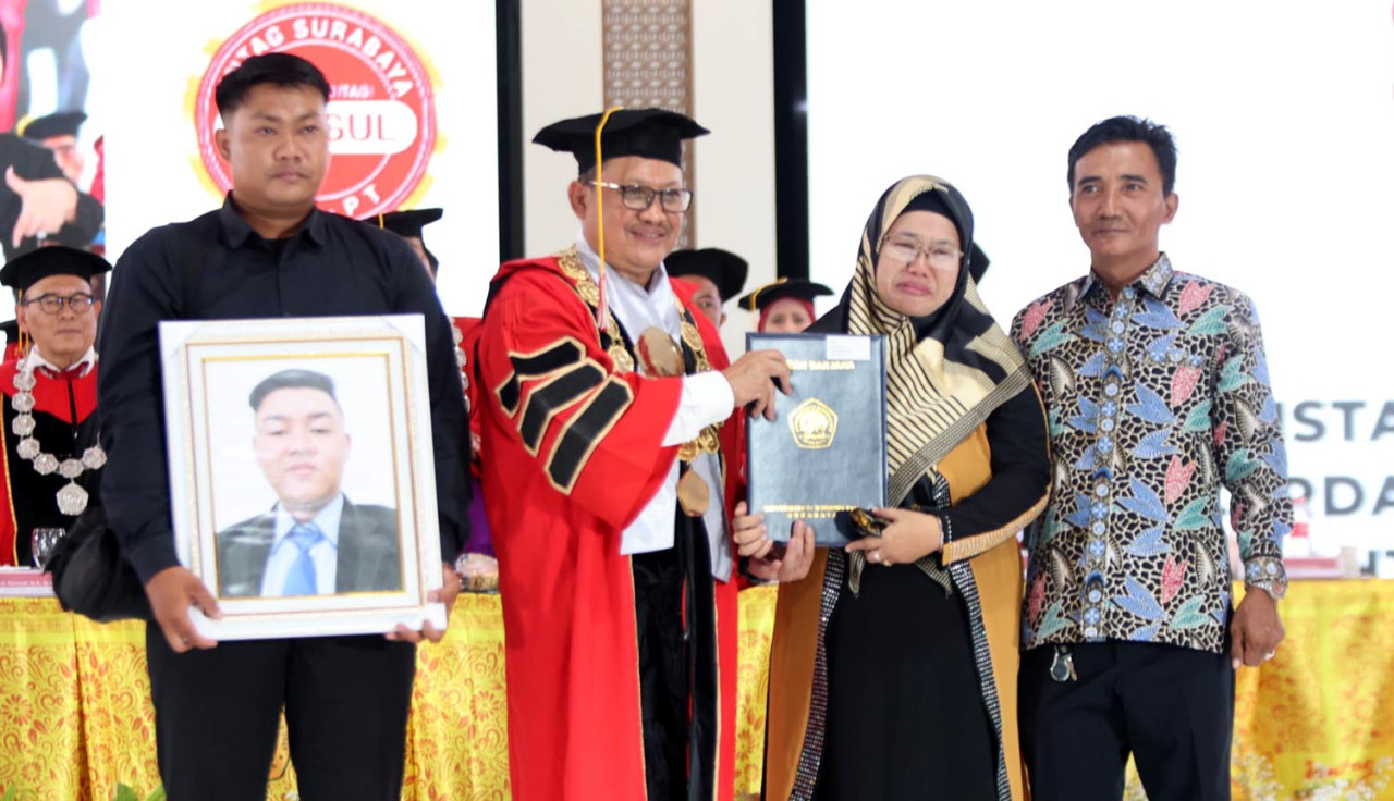 Rektor Untag Surabaya,Prof. Mulyanto Nugroho, memberikan penghormatan khusus kepada Firman Febriansyah, wisudawan dari Prodi Teknik Elektro yang dinyatakan lulus in absentia karena telah meninggal dunia. (Foto: Humas Untag Surabaya for JatimNow.com) 