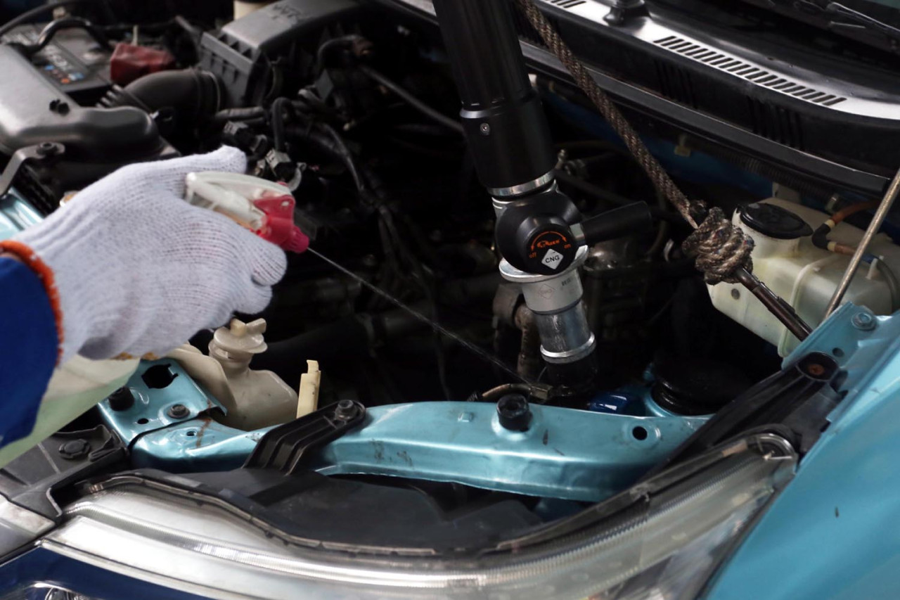 Petugas menyemprotkan cairan berbusa ke converter kit saat proses pengisian bahan bakar gas (BBG) di Stasiun pengisian BBG (SPBG) Ngagel Surabaya, Kamis (18/9/2025). Penyemprotan tersebut untuk memastikan tidak ada kebocoran. (Foto: Ali Masduki/JatimNow.com).