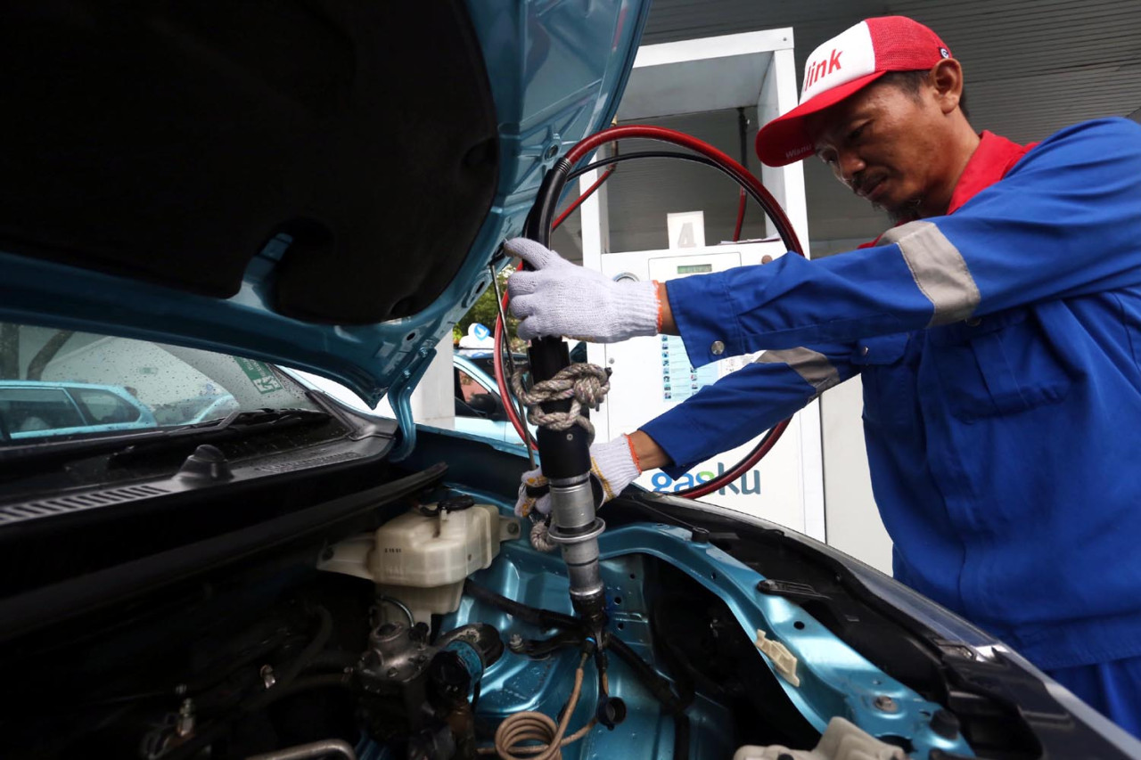 Petugas melayani pengisian GasKU, merek produk bahan bakar gas (BBG) di Stasiun pengisian BBG (SPBG) Ngagel Surabaya, Kamis (18/9/2025). Layanan BBG menunjukkan komitmen PGN untuk mendukung pemerintah terutama program konversi BBM ke BBG, agar masyarakat menggunakan bahan bakar kendaraan yang lebih ramah lingkungan. (Foto: Ali Masduki/JatimNow.com).