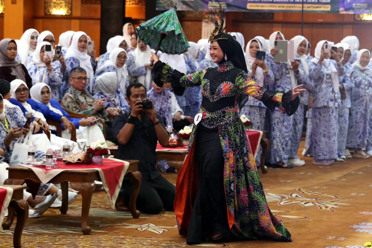 Anggota IWAPI Jatim memamerkan rancangan dan kurasi produk dalam parade fashion show ketika pembukaan Rapat Kerja Daerah (Rakerda) IV DPD IWAPI Jatim pada Senin (22/9/2025). (Foto: Ali Masduki/JatimNow.com)