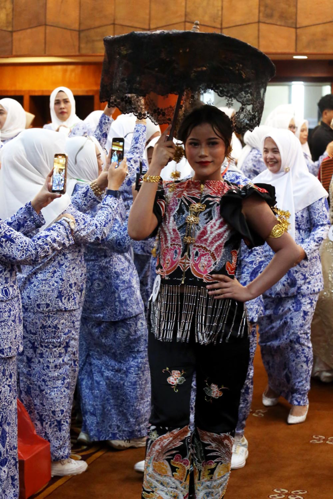 Parade fashion ini juga menjadi ruang pembelajaran langsung. Anggota IWAPI Jatim memamerkan rancangan dan kurasi produk dalam parade fashion show ketika pembukaan Rapat Kerja Daerah (Rakerda) IV DPD IWAPI Jatim pada Senin (22/9/2025).(Foto: Ali Masduki/JatimNow.com)