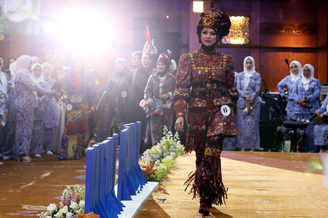 Beragam busana khas Jawa Timur dibawakan oleh anggota IWAPI Jatim dalam parade fashion show ketika pembukaan Rapat Kerja Daerah (Rakerda) IV DPD IWAPI Jatim pada Senin (22/9/2025). (Foto: Ali Masduki/JatimNow.com)
