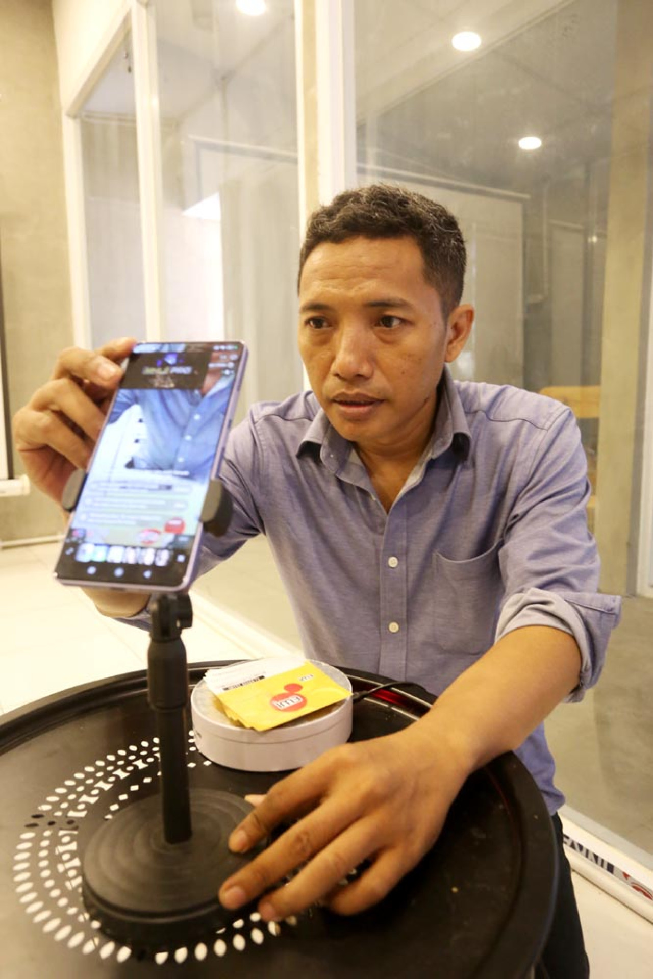 Isnan Effendi menyiapkan kartu cantik untuk live TikTok, di Rumah Literasi Digital (RLD) Jl. Kaca Piring, Surabaya. (Foto: Ali Masduki/JatimNow.com)