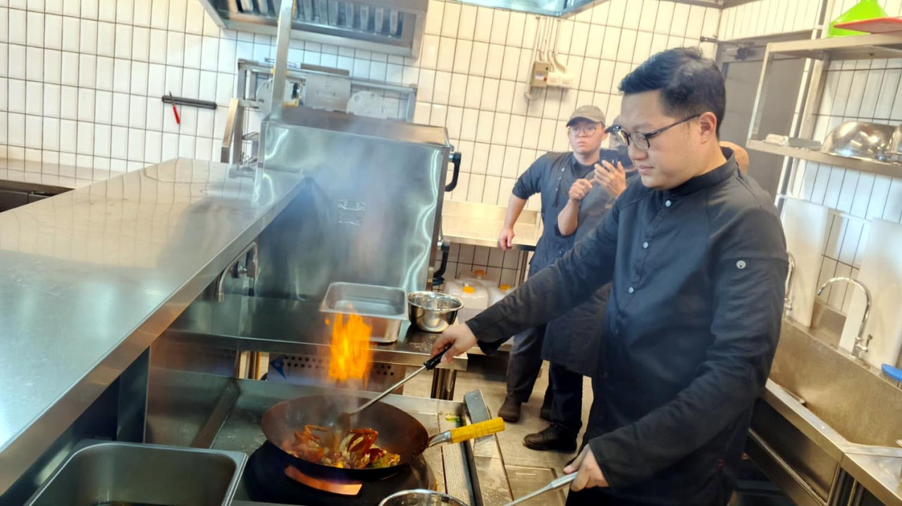 Chef Jimmy mengolah kepiting pesanan pelanggan, di Crab di Crab n Co, Citraland, Surabaya, Selasa (02/9/2025). (Foto: Ali Masduki/jatimnow.com)