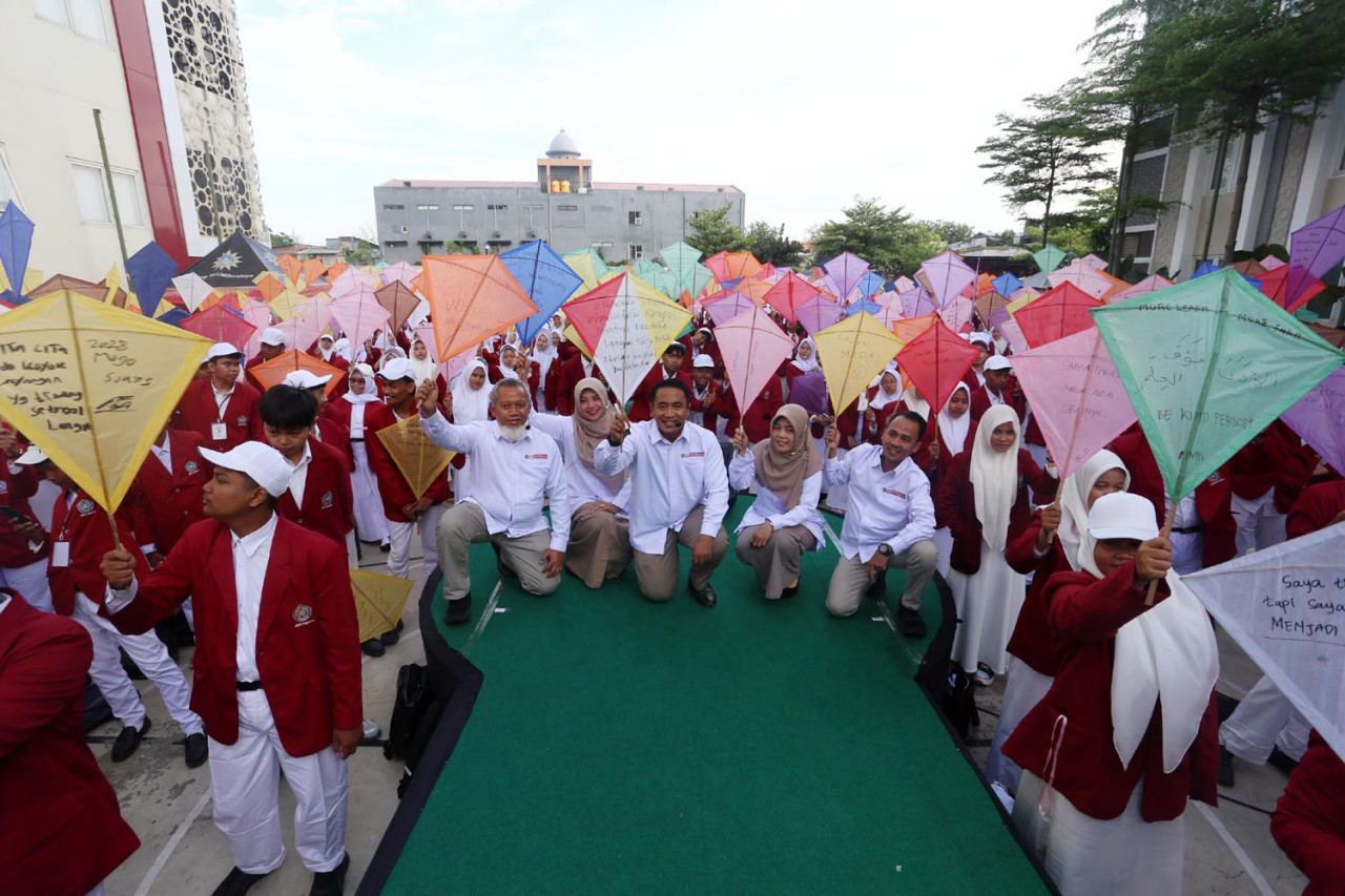 Rektor UM Surabaya, Mundakir, bersama jajaran menerbangkan layang-layang bersama ribuan mahasiswa baru dalam pembukaan Masa Orientasi (MOX) 2025. (Foto: Ali Masduki/JatimNow.com)