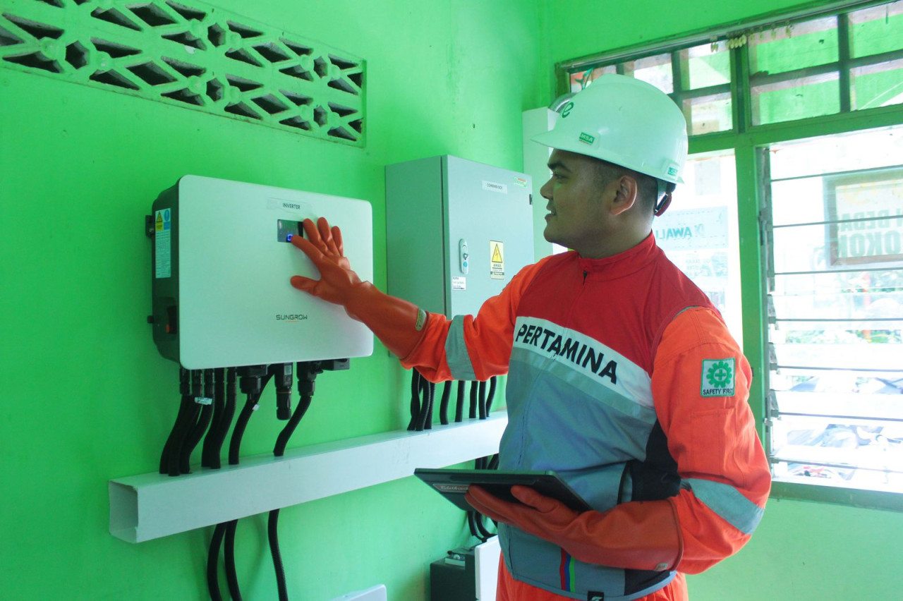 Petugas dari Pertamina Lubricants melakukan pengecekan inverter dan baterai PLTS di Balai RW 002 Kelurahan Pekauman, Gresik, yang menjadi ruang kerajinan Batik Leles. (Foto: Sahlul Fahmi/jatimnow.com)