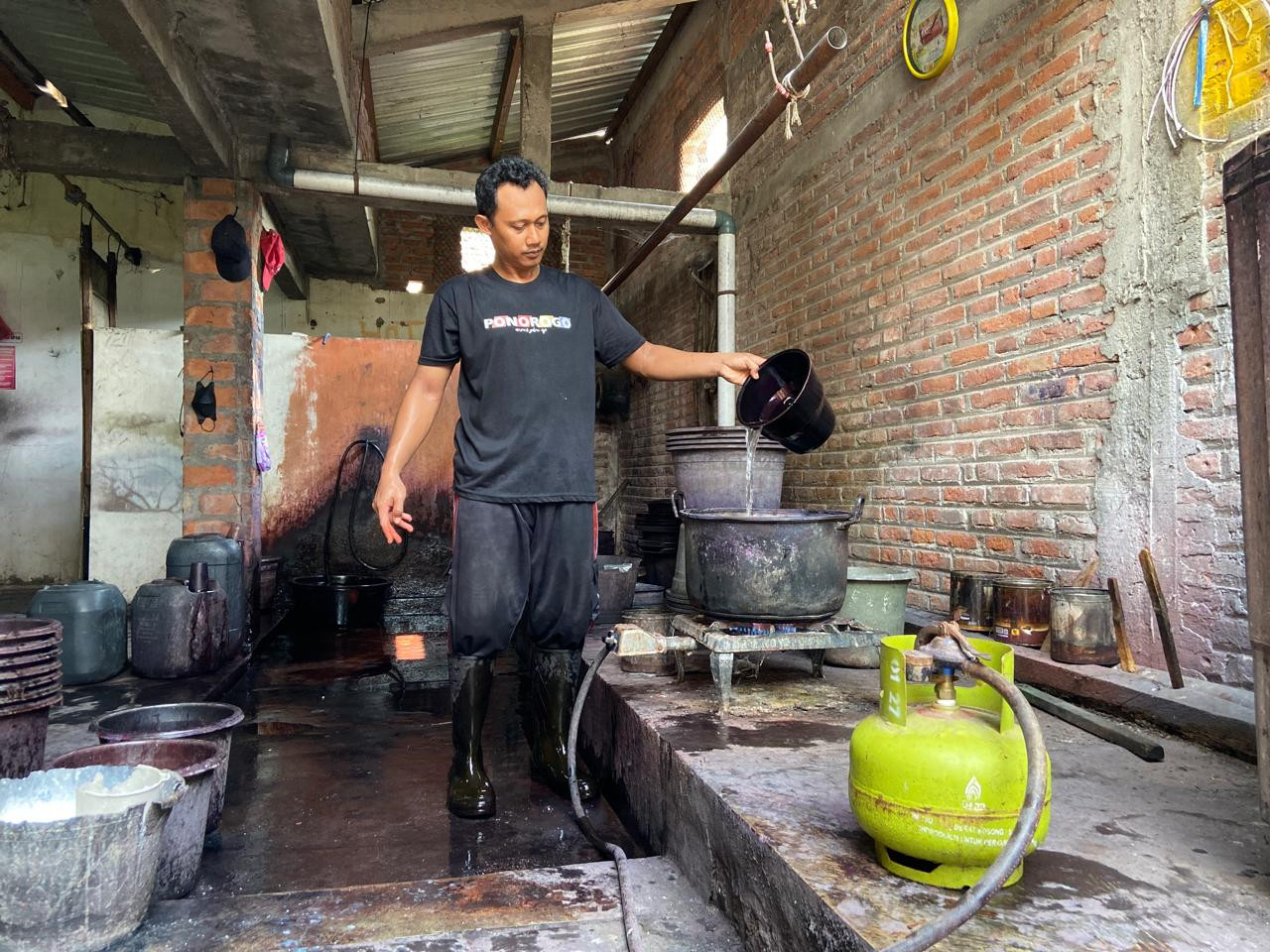 Zuhri sedang merebus air dengan LPG 3 kilogram. Air dengan panas sempurna ini digunakan untuk pencelupan warna yang maksimal.