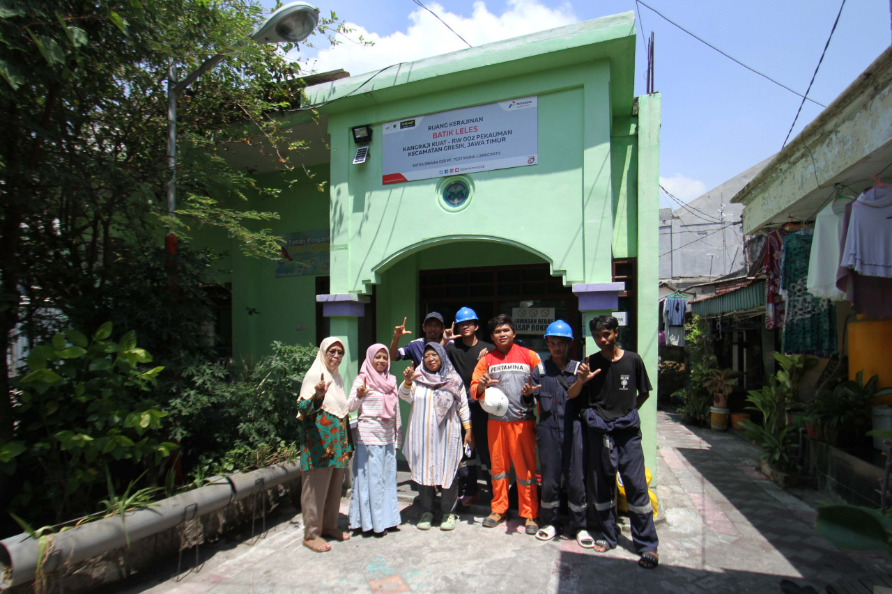 Petugas dari Pertamina Lubricants foto bersama kader Batik Leles di Balai RW 002 Pekauman, Kecamatan/Kabupaten Gresik, yang menjadi ruang kerajinan Batik Leles. (Foto: Sahlul Fahmi/jatimnow.com)