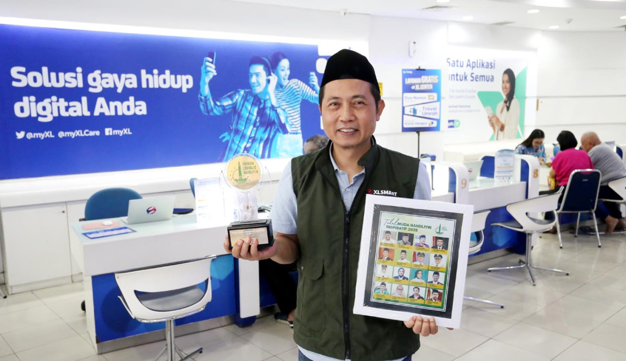 Group Head East Region XLSMART, Dodik Ariyanto, memegang penghargaan dari Forkom Jurnalis Nahdliyin (FJN). (Foto: Ali Masduki/jatimnow.com)
