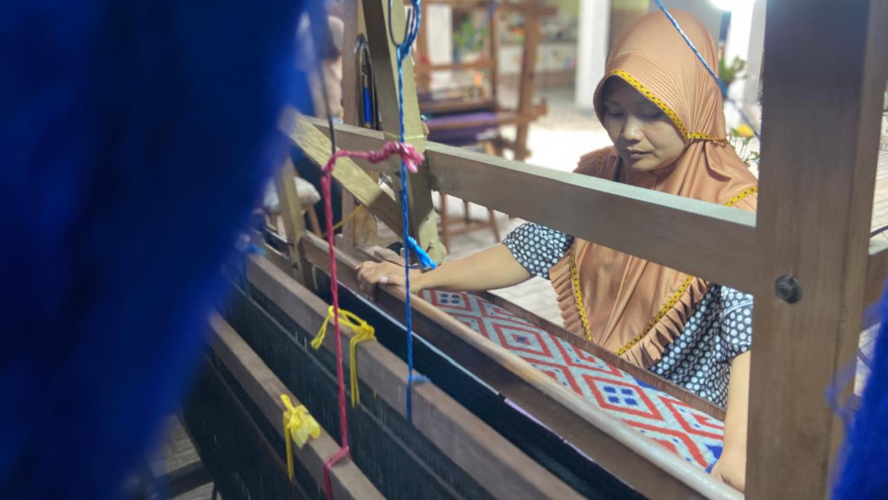 Mira salah satu pekerja di Medali Mas tengah menyelesaikan selembar tenun ikat. (Foto: Yanuar Dedy/jatimnow.com)