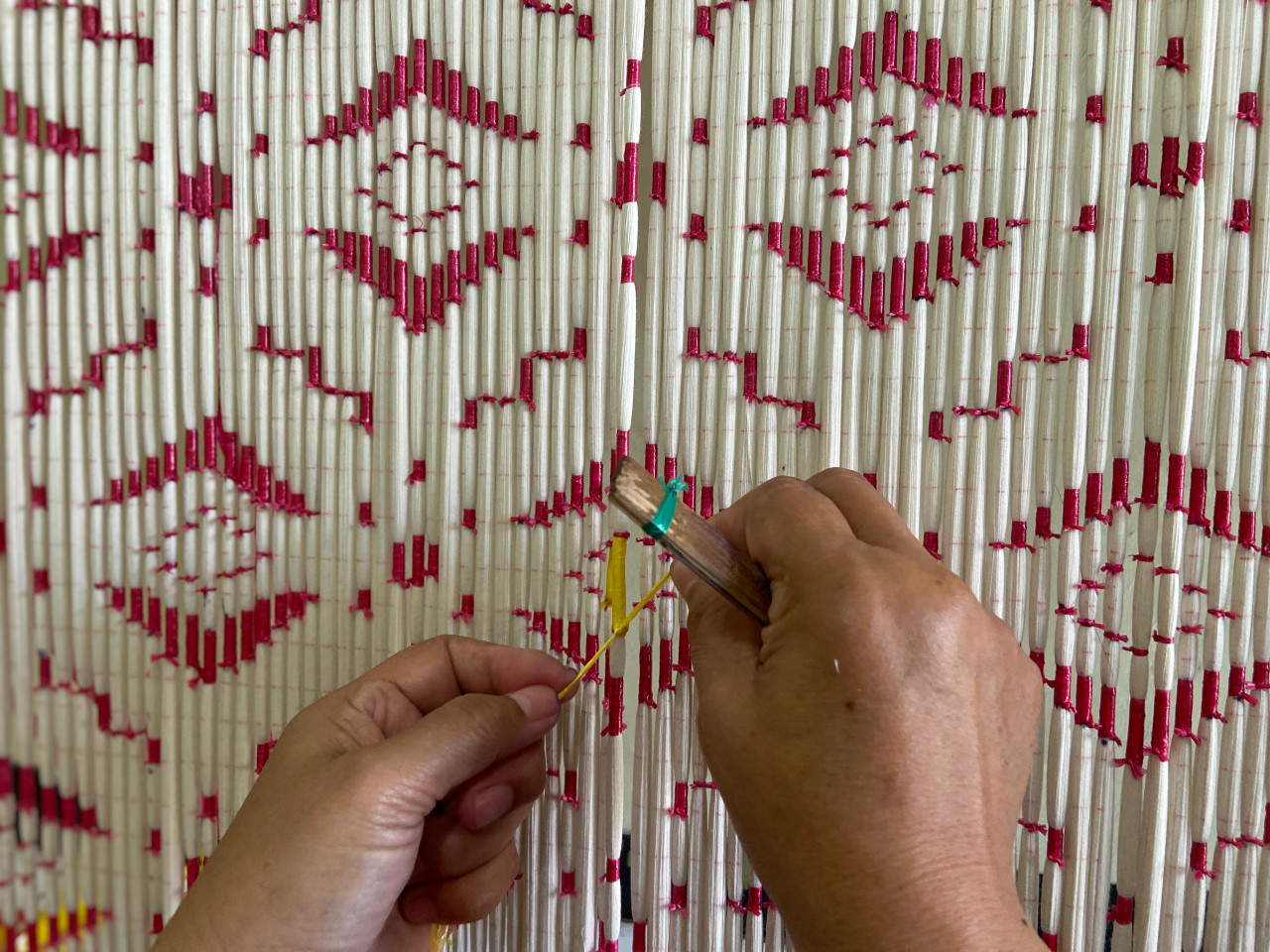 Detil pekerjaan Umaha Tikum (53). Kerumitan desain ini yang menentukan upah yang ia terima, mulai dari Rp40–60 ribu. Saat ini, dia menjadikan pekerjaan tersebut satu-satunya seiring upah yang meningkat.