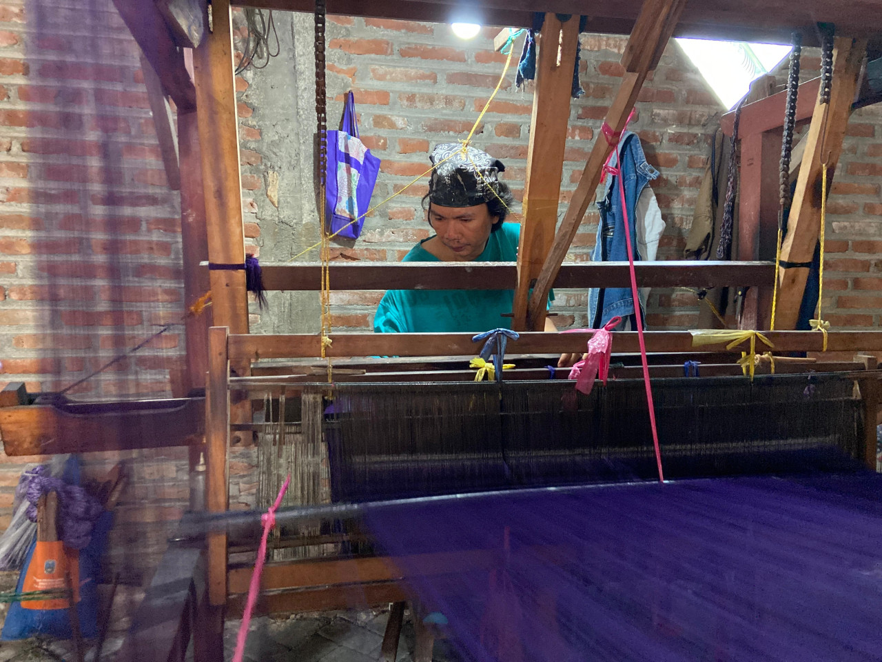 Sukoco (38) sedang melakukan penenunan dengan Alat Tenun Bukan Mesin (ATBM). Tahap ini juga dilakukan dalam satu lokasi bersama pencelupan.