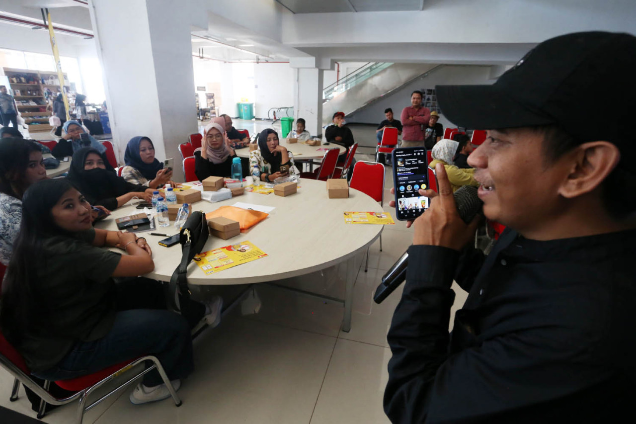 Fatchur Rohman atau Partok membedah salah satu akun media sosial milik peserta ketika menjadi pemateri dalam program Indosat Empowering UMKM bath 2, di MCC, Kamis (02/10/2025). (Foto: Ali Masduki/jatimnow.com)