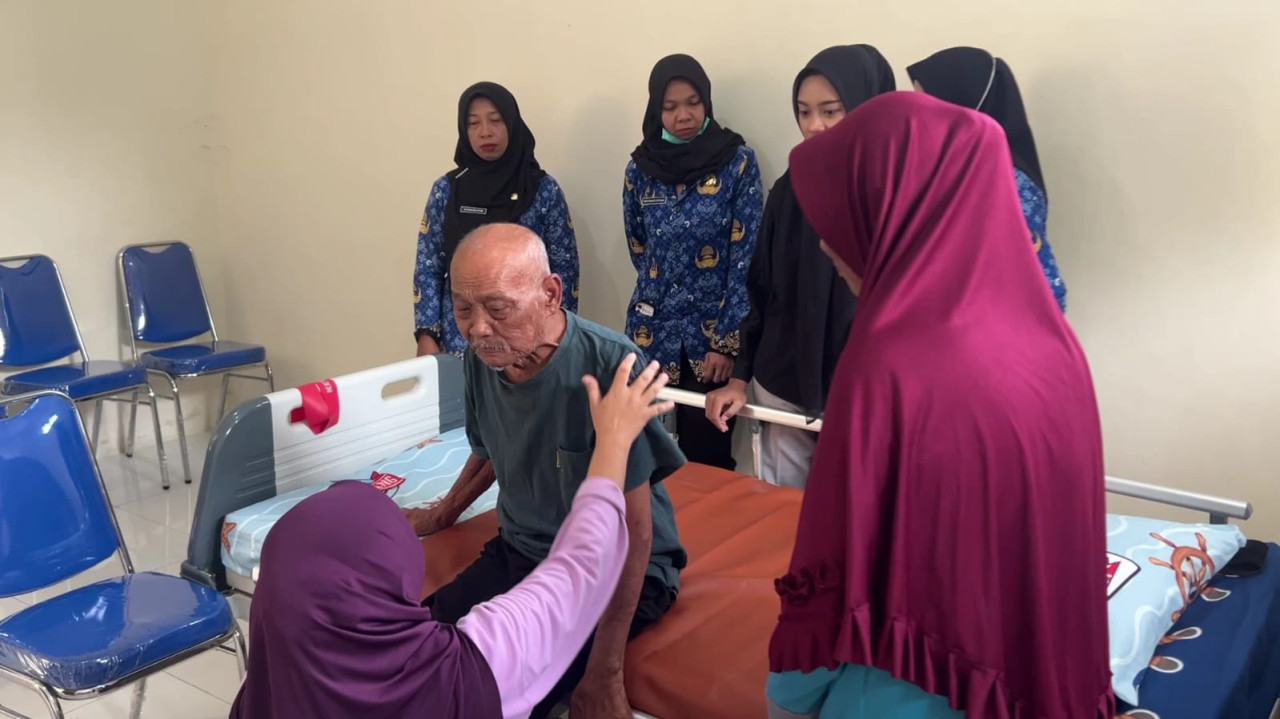 Foto: Petugas saat memberi layanan fisioterapi kepada pasien lansia. (Bramanta/jatimnow.com)