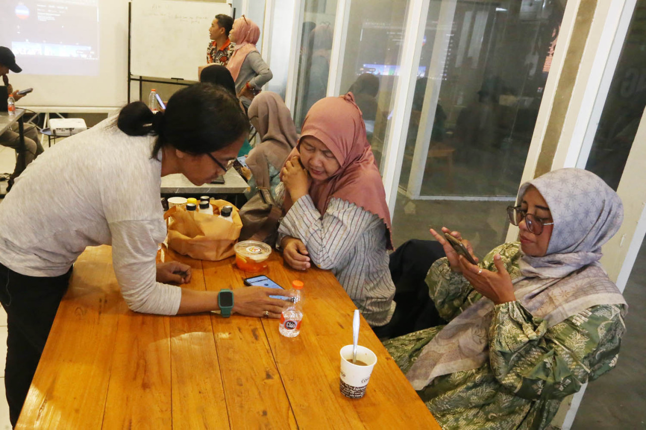 Andika Ismawan memandu pelaku UMKM ketika mengikuti pelatihan digital marketing di Rumah Literasi Digital (RLD), di Balai RW-RLD, Jl Kaca Piring 6 Surabaya, Selasa (30/9/2025). (Foto: Ali Masduki/jatimnow.com)