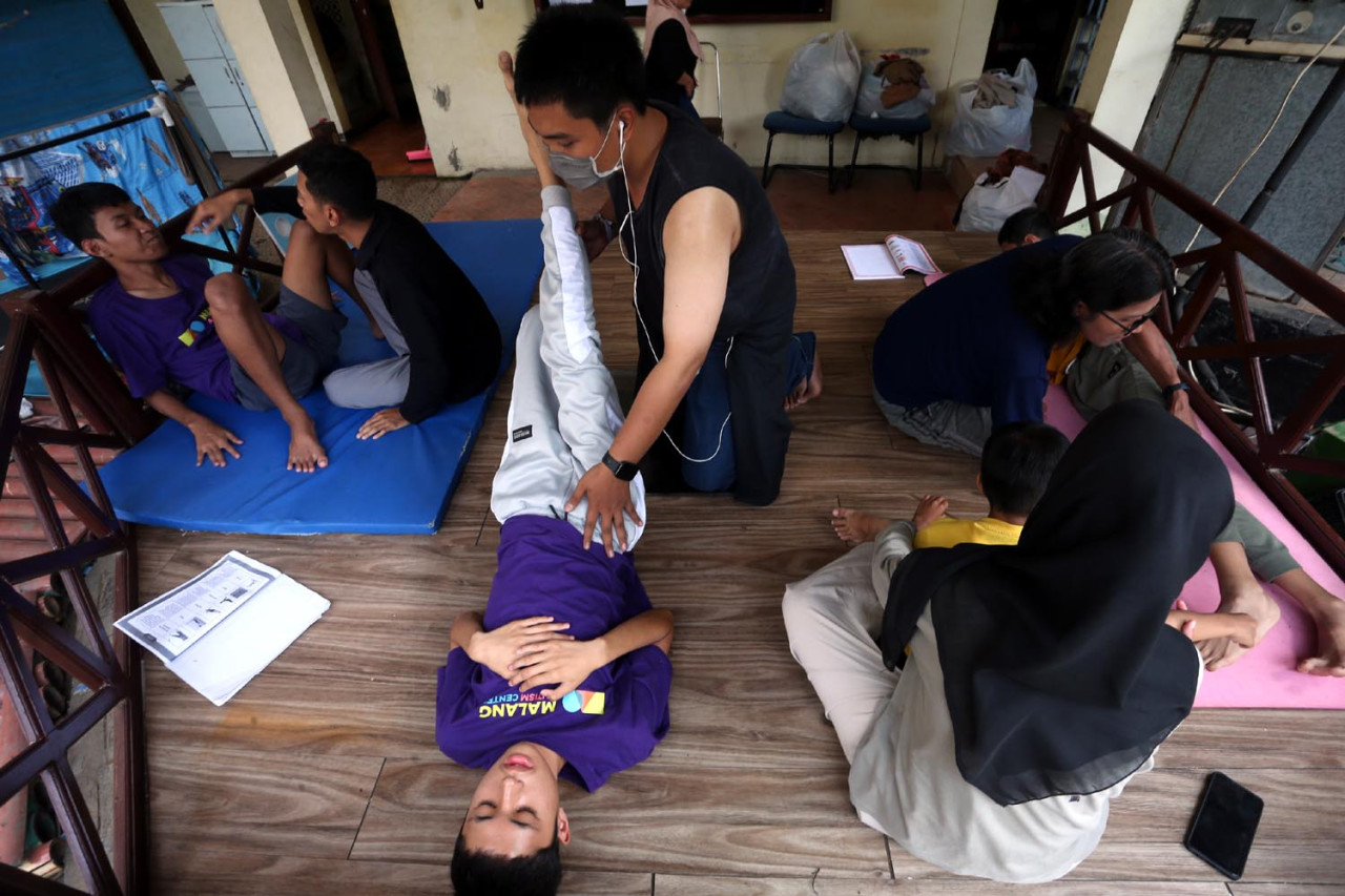 Para terapis Malang Autism Center mendampingi anak-anak autisme menjalani sesi terapi fisik di ruang terbuka. Setiap gerakan, sentuhan, dan instruksi dilakukan dengan penuh kesabaran untuk melatih koordinasi tubuh, fokus, serta kontrol emosi. Di balik suasana sederhana itu, tersimpan dedikasi besar para terapis yang setiap hari berjuang menuntun anak-anak istimewa menuju kemandirian. (Foto: Ali Masduki/jatimnow.com)