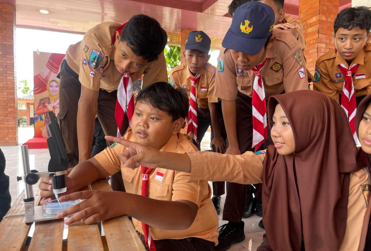 Beberapa siswa dan guru mencoba menguji sampel Air Minum Dalam Kemasan (AMDK) yang mereka bawa sendiri. (Foto:Ecoton for JatimNow.com)