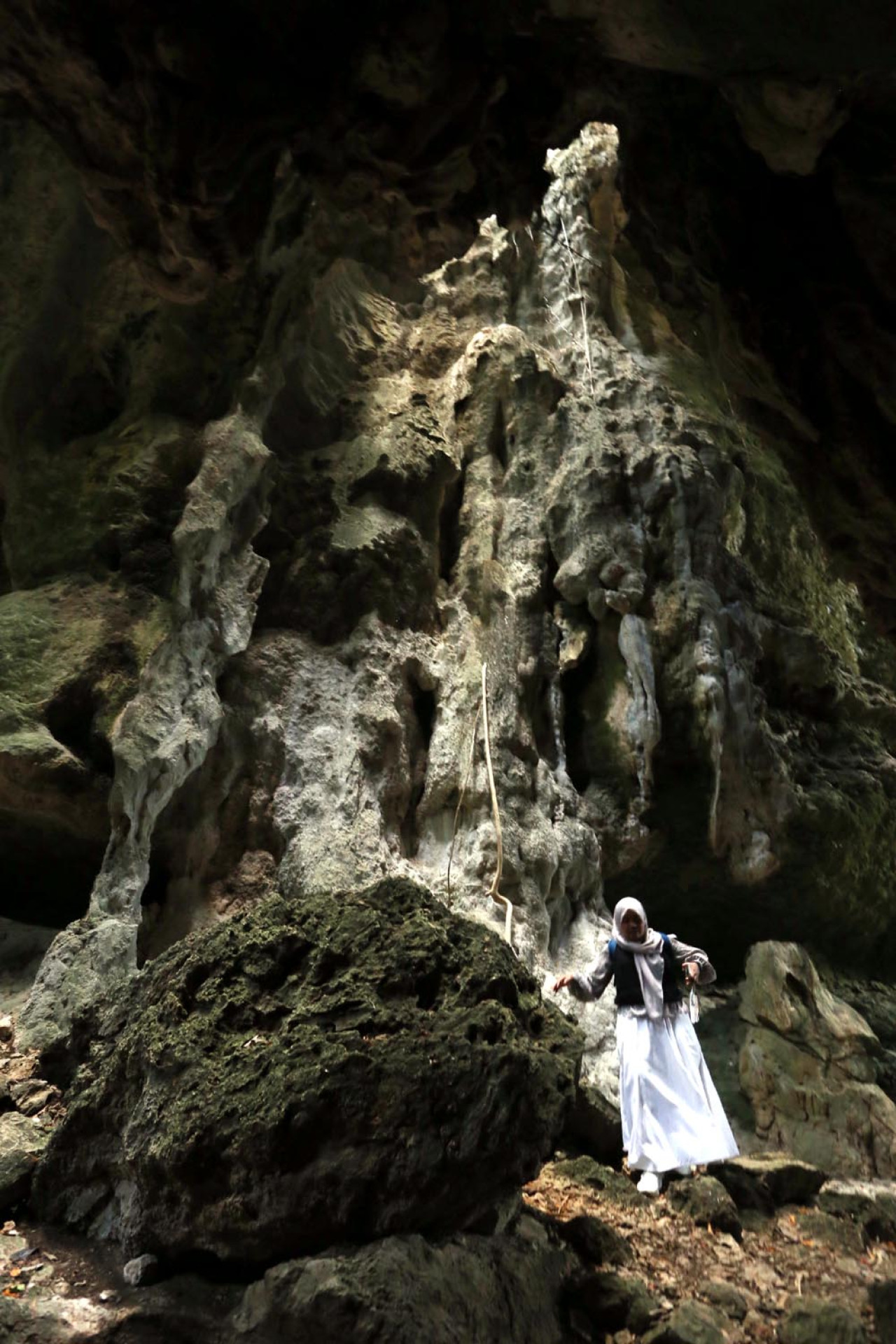 Seorang wisatawan berjalan di antara bebatuan ketika berkunjung di Goa Batu Cermin, Labuan Bajo, Manggarai Barat. (Foto: Ali Masduki/JatimNow.com)