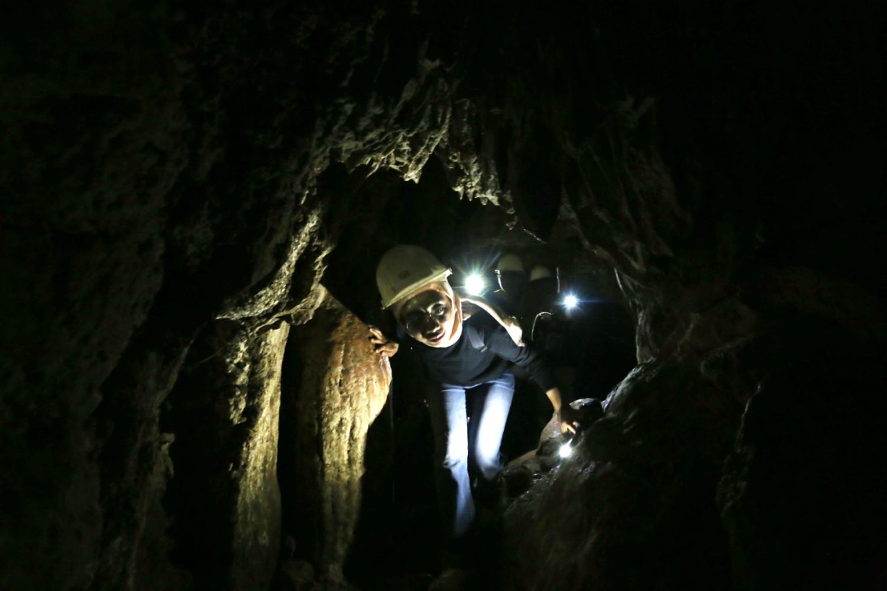 Wisatawan dari UM Surabaya keluar dari dalam ikon Goa Batu Cermin. (Foto: Ali Masduki/JatimNow.com)