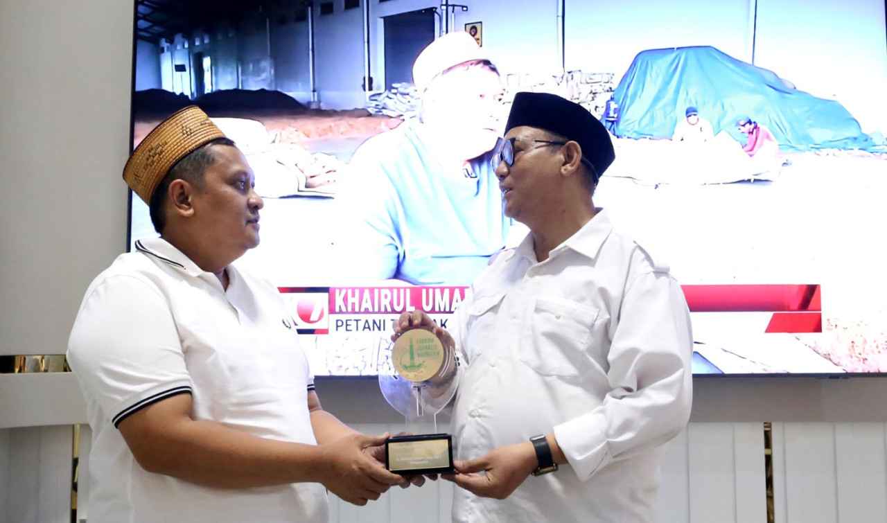 Ketua Umum FJN, Muhamad Didi Rosadi, menyerahkan penghargaan kepada Haji Her, di Surabaya, Jumat (31/10/2025). (Foto: Ali Masduki/jatimnow.com)
