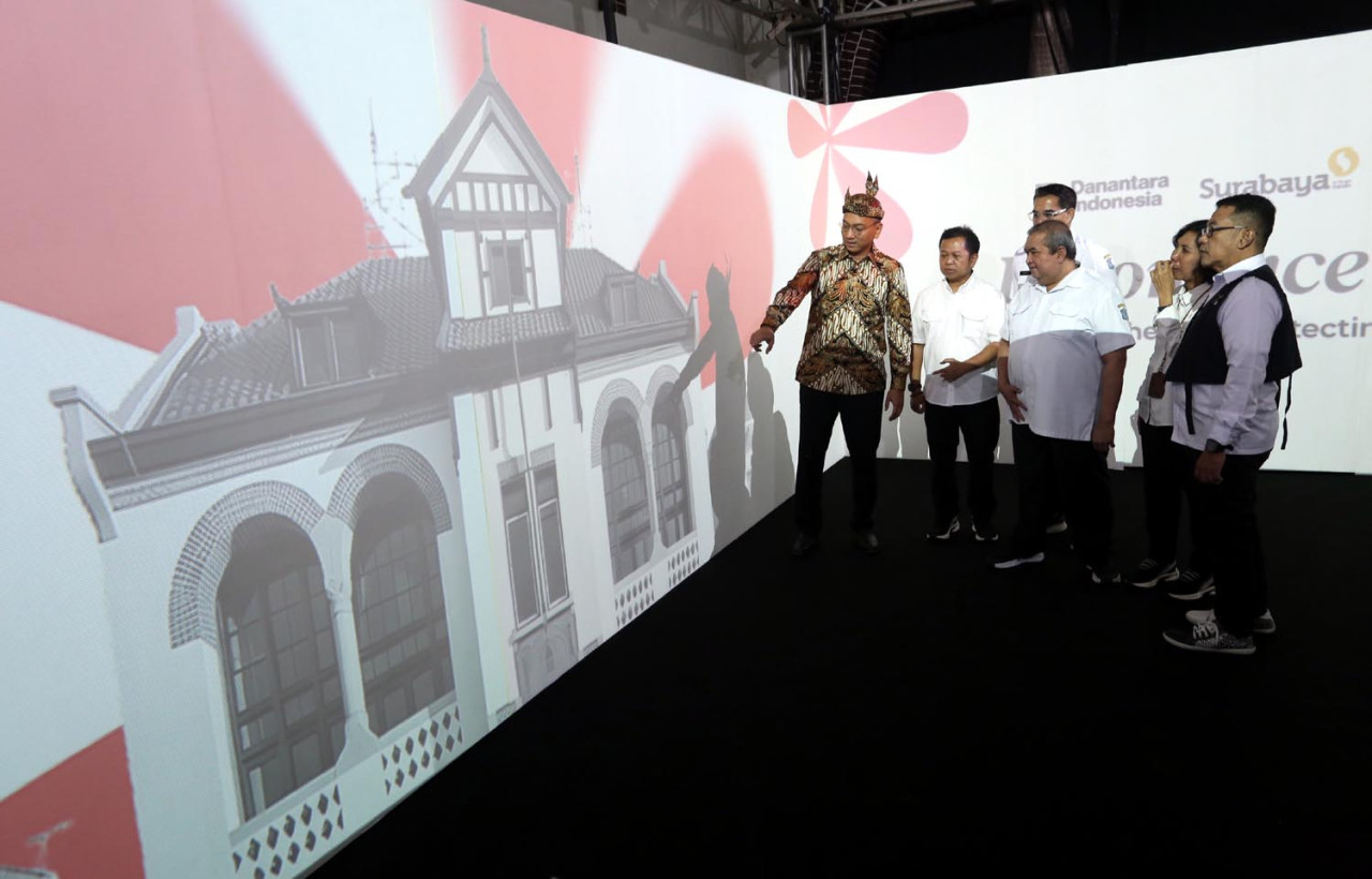Direktur Investasi IFG Life, Mufri Dharmawan, bersama perwakilan pemnkot Surabaya menyaksikan visual imersif di Gedung Singa, Surabaya, Rabu (19/11/2025). (Foto: Ali Masduki/jatimnow.com)