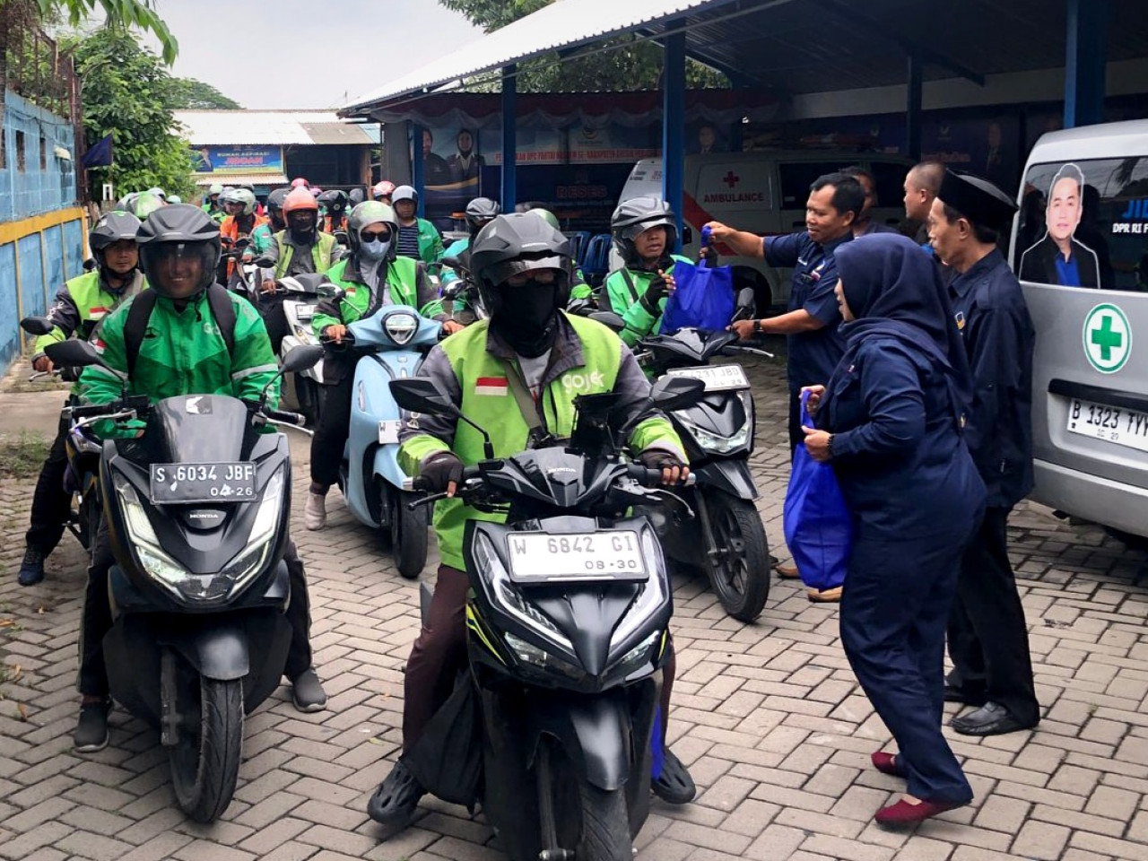 Pengemudi ojek online saat menerima bingkisan sembako gratis dari DPD NasDem Kabupaten Gresik. (Foto: Sahlul Fahmi/jatimnow.com)