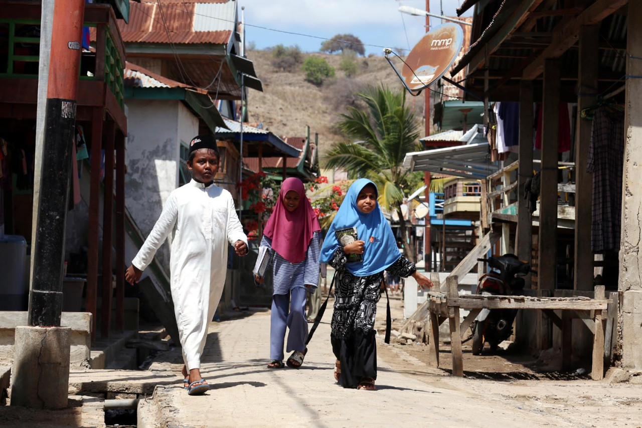 Tiga anak berjalan di jalanan desa usai mengaji. Di Pulau Komodo yang dihuni 2000 jiwa yang terbagi dalam 500 KK ini, mayoritas masyarakatnya adalah Islam. (Foto: Ali Masduki/JatimNow.com)