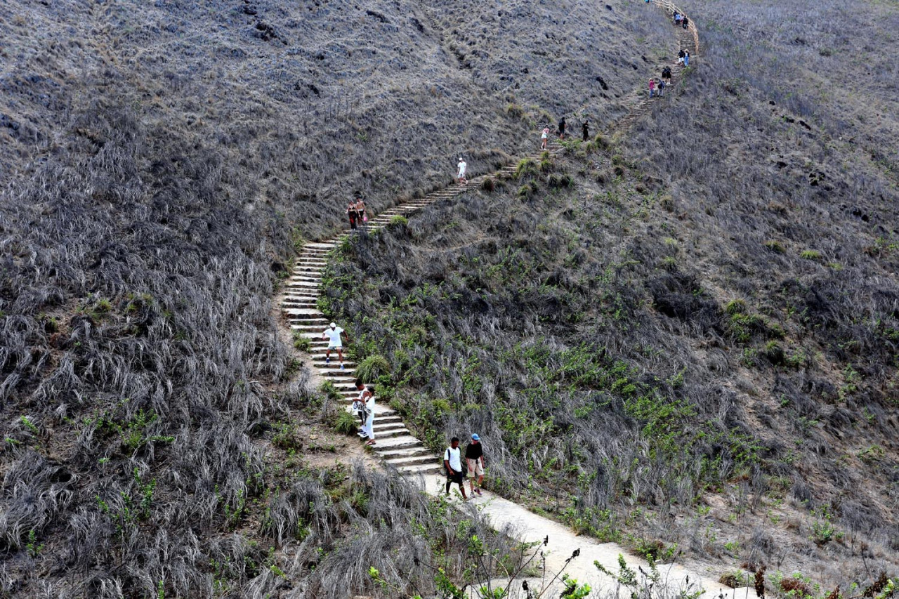 Pulau Padar menjadi destinasi favorit wisatawan lokal dan mancanegara berkat keindahan lanskap savananya serta laut biru yang mengelilinginya. Aktivitas trekking dan fotografi alam menjadi daya tarik utama kawasan konservasi ini yang juga merupakan bagian dari Taman Nasional Komodo, situs warisan dunia UNESCO. (Foto: Ali Masduki/JatimNow.com)