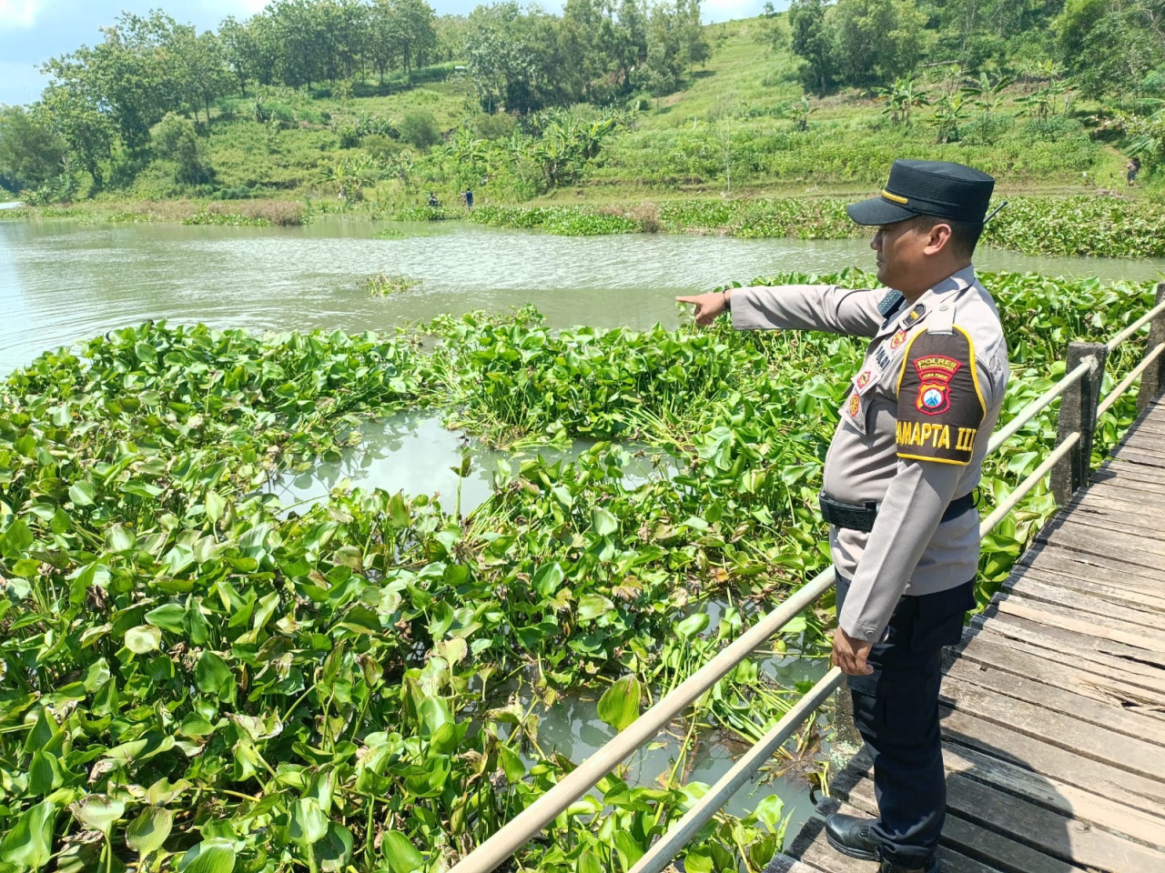Petugas kepolisian menunjukkan lokasi tenggelamnya bocah di Sungai Bodeng Tulungagung. (Foto: Bramanta Pamungkas/jatimnow.com)