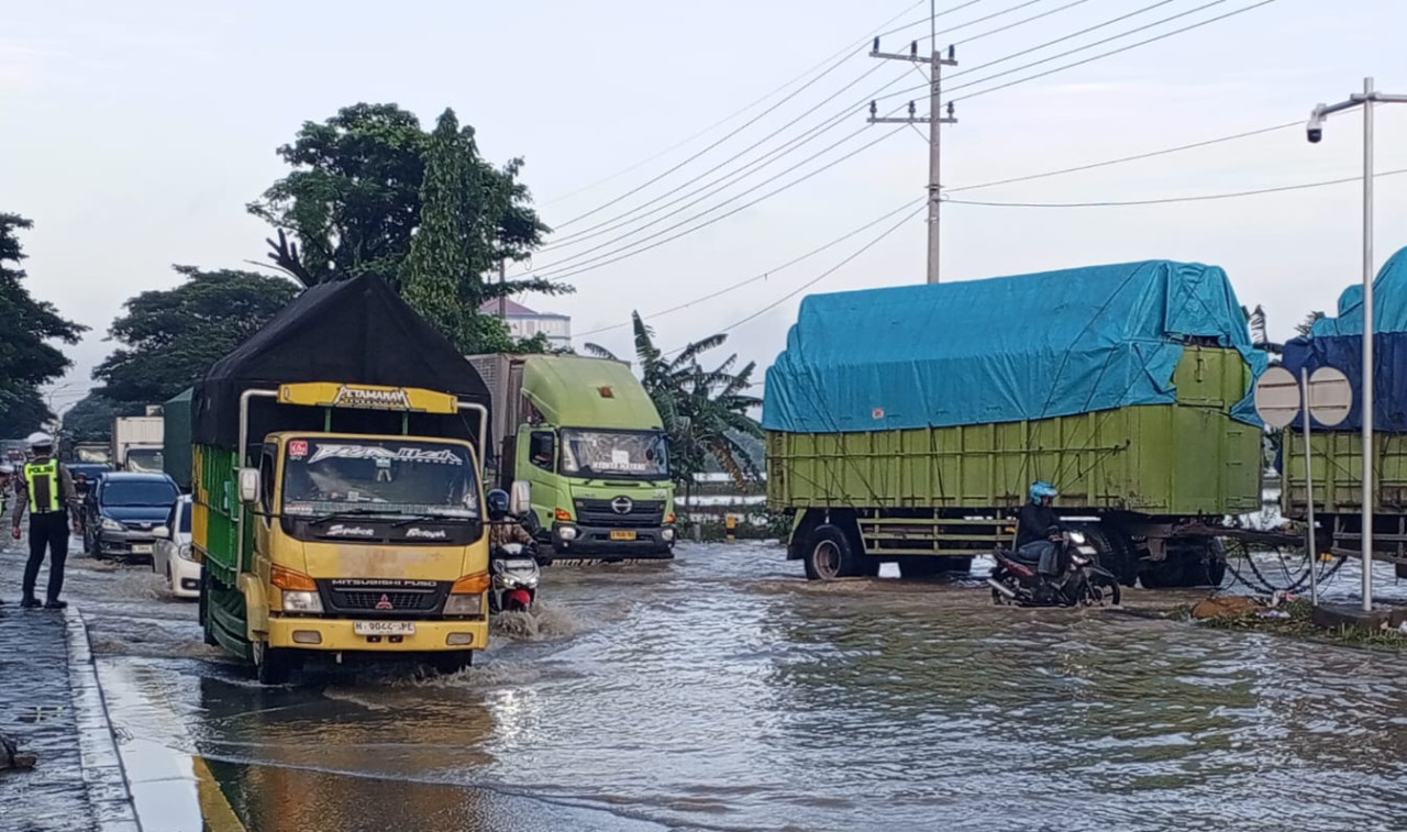Foto: Banjir luapan sungai di Lamongan rendam jalan poros nasional hingga menyebabkan kemacetan. (Adyad Ammy Iffansah/jatimnow.com).