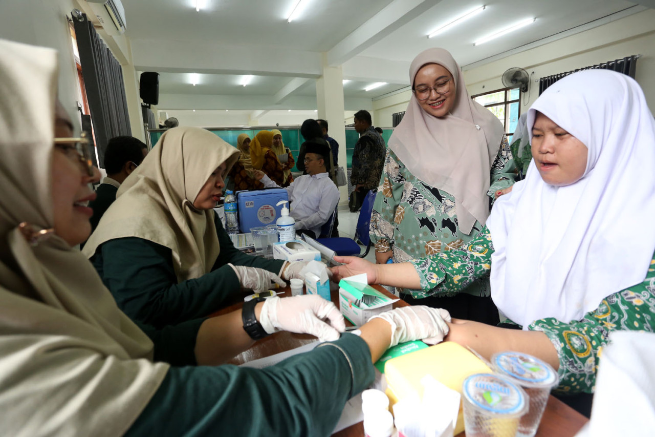 Seorang santriwati menjalani pemeriksaan kesehatan oleh tenaga medis dalam Program Cek Kesehatan Gratis (CKG) di Pondok Pesantren Modern Sunanul Muhtadin, Gresik, Kamis (18/12/2025). Kegiatan ini merupakan bagian dari upaya pemerintah memperluas layanan kesehatan serta melakukan deteksi dini penyakit pada anak dan remaja di lingkungan pesantren.(Foto: Ali Masduki/jatimnow.com)