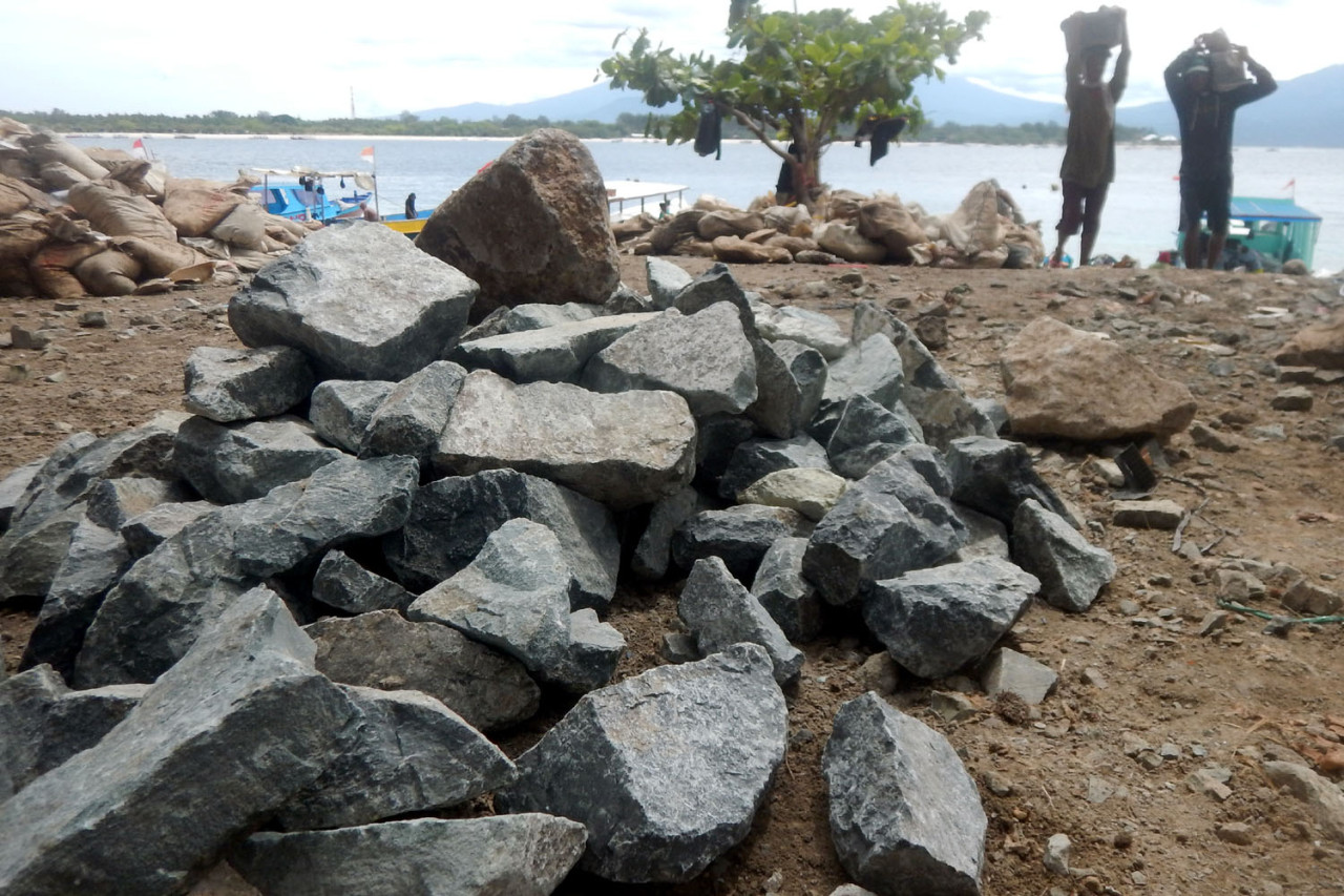 Tumpukan batu menjadi saksi mahalnya ongkos pembangunan di Gili Trawangan. Tanpa kendaraan bermotor dan alat berat, material bangunan diangkut manual dari perahu ke daratan. Di balik pesona pulau wisata, fondasi bangunan berdiri di atas kerja keras dan keringat para kuli angkut.(Foto: Ali Masduki/jatimnow.com)