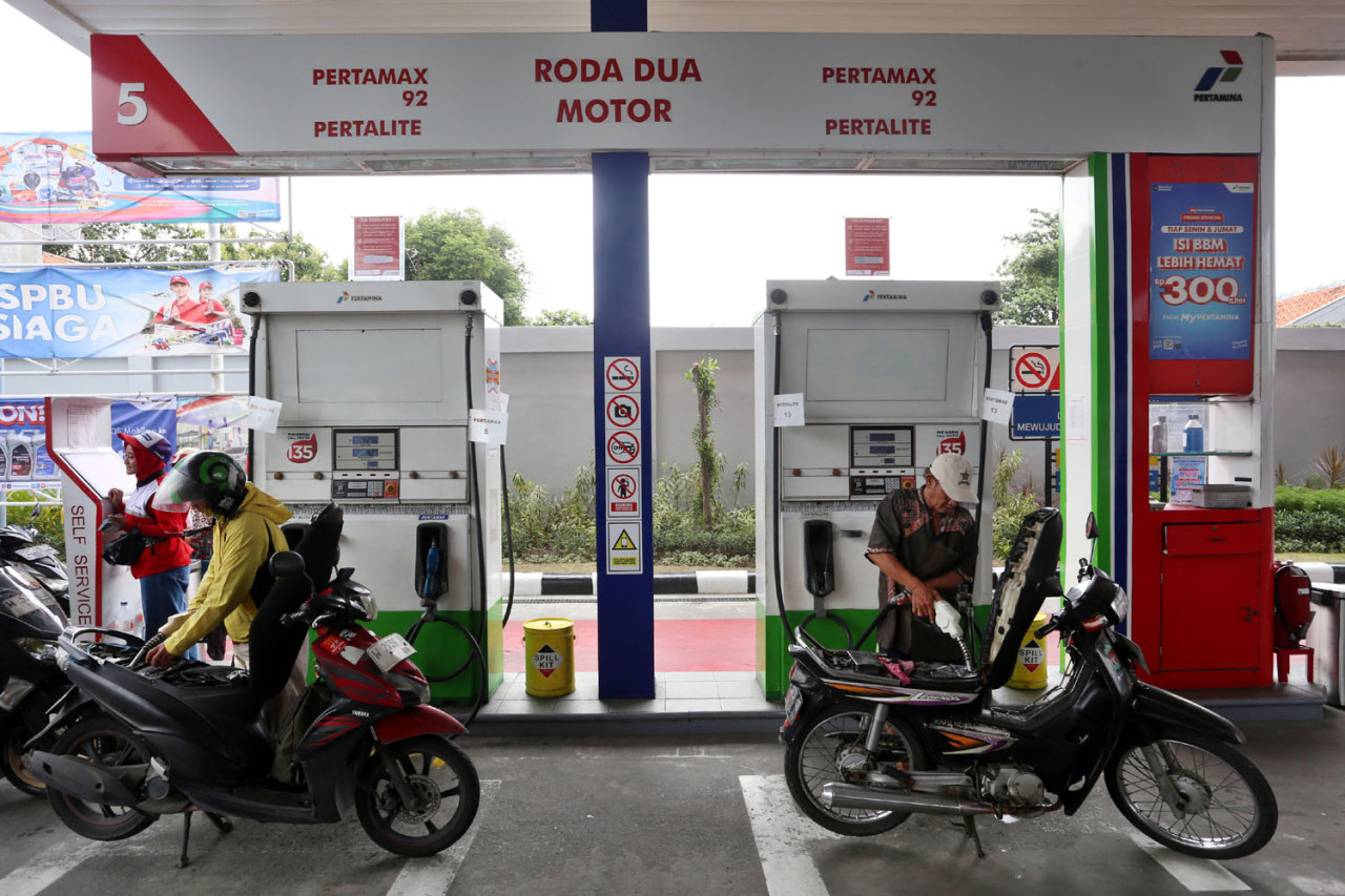 Pengendara sepeda motor mengisi bahan bakar secara mandiri di jalur khusus roda dua SPBU COCO Jemursari, Surabaya, Rabu (24/12/2025). Melalui sistem self-service, konsumen mengaktifkan dispenser dengan barcode pembayaran dan mengisi BBM sendiri sesuai kebutuhan. Layanan ini menjadi bagian dari transformasi SPBU menuju sistem yang lebih modern, efisien, dan terintegrasi dengan digitalisasi MyPertamina.(Foto: Ali Masduki/jatimnow.com)