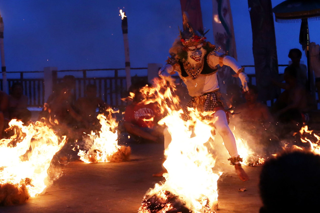 Aksi heroik Anoman menari di tengah kobaran api menghadirkan suasana magis dan menegangkan dalam pementasan Tari Kecak Bali. (Foto: Ali Masduki/jatimnow.com)