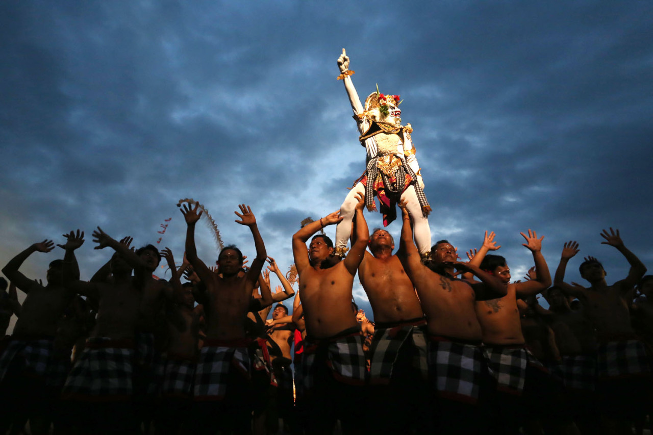 Momen klimaks Tari Kecak Bali menampilkan Anoman diangkat pasukan Wanara, menciptakan komposisi visual dramatis di bawah langit gelap. (Foto: Ali Masduki/jatimnow.com)