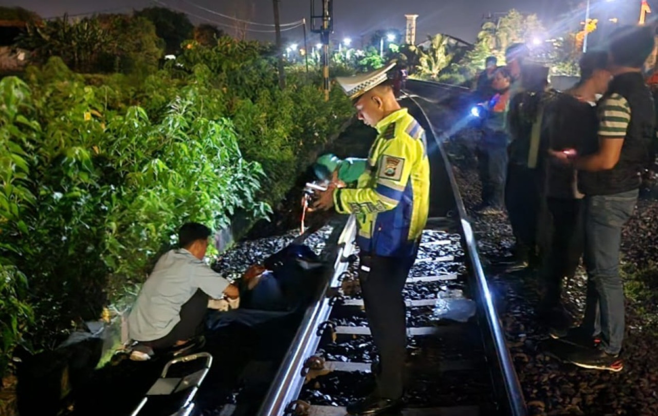 Foto: Evakuasi pria meninggal di sebelah Rel KA Lamongan. (Humas Polres Lamongan/jatimnow.com)
