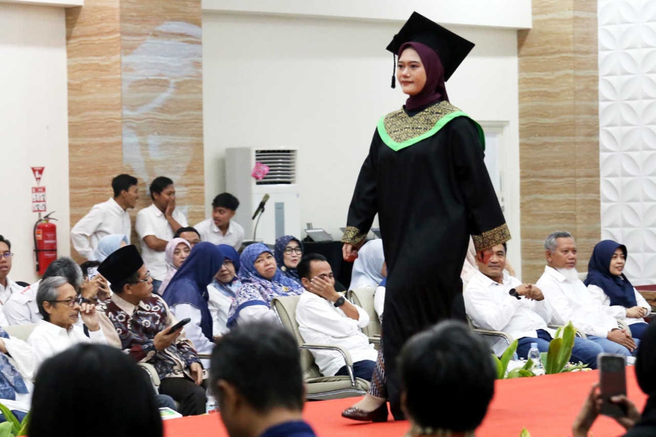 Mahasiswa mengenalkan baju wisuda dalam acara runway Catwalk Fashion Show Rebranding UMSURA. Fashion show ini merupakan bagian dari perayaan rebranding yang memperkenalkan identitas dan wajah baru kampus.(Foto: Ali Masduki/jatimnow.com)
