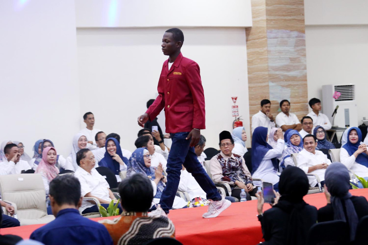 Mahasiswa memperagakan almamater dalam acara runway Catwalk Fashion Show Rebranding UMSURA. Fashion show ini merupakan bagian dari perayaan rebranding yang memperkenalkan identitas dan wajah baru kampus.(Foto: Ali Masduki/jatimnow.com)