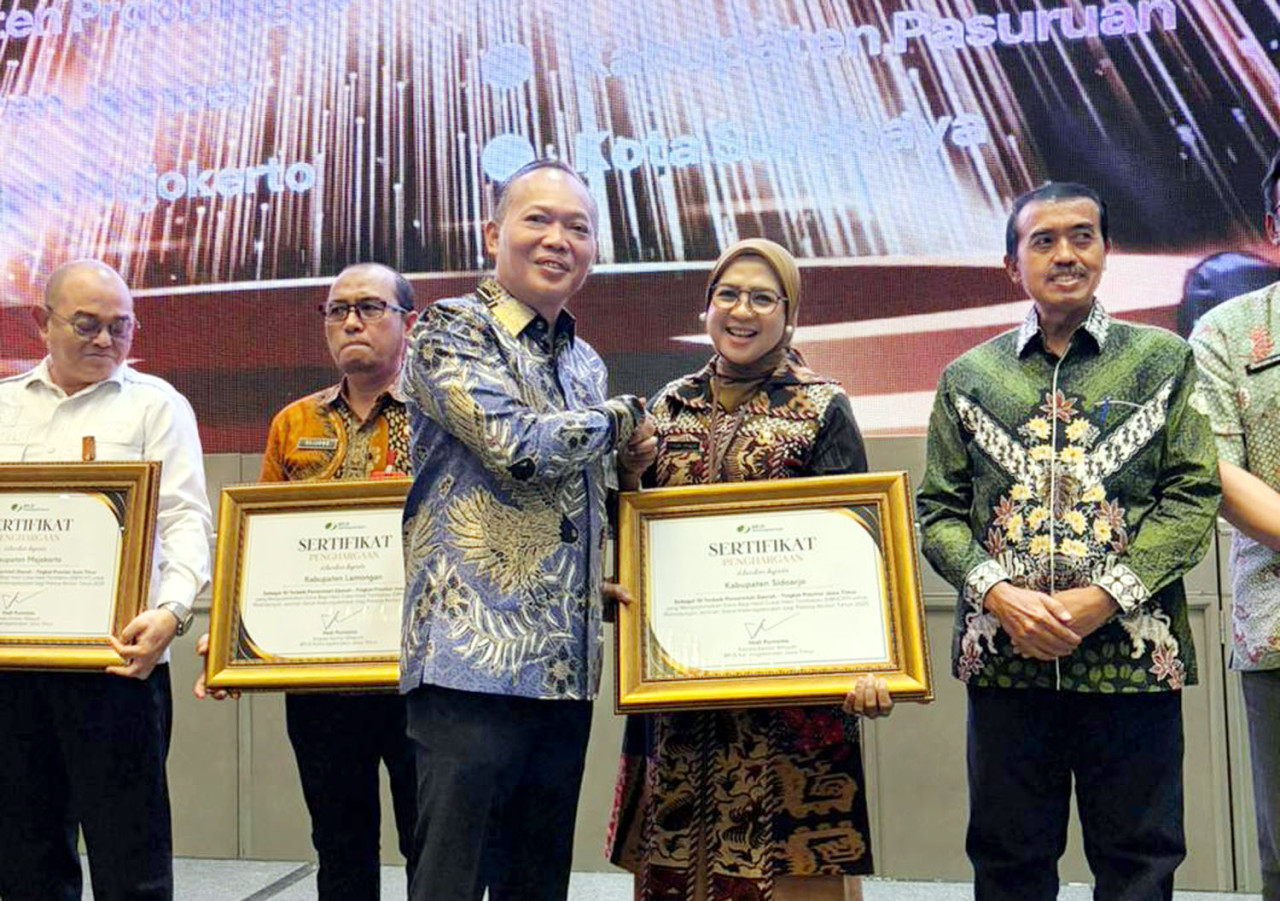 Kepala Kantor Wilayah BPJS Ketenagakerjaan Jawa Timur, Hadi Purnomo, menyerahkan penghargaan Universal Coverage Jamsostek 2025. (Foto/jatimnow.com)