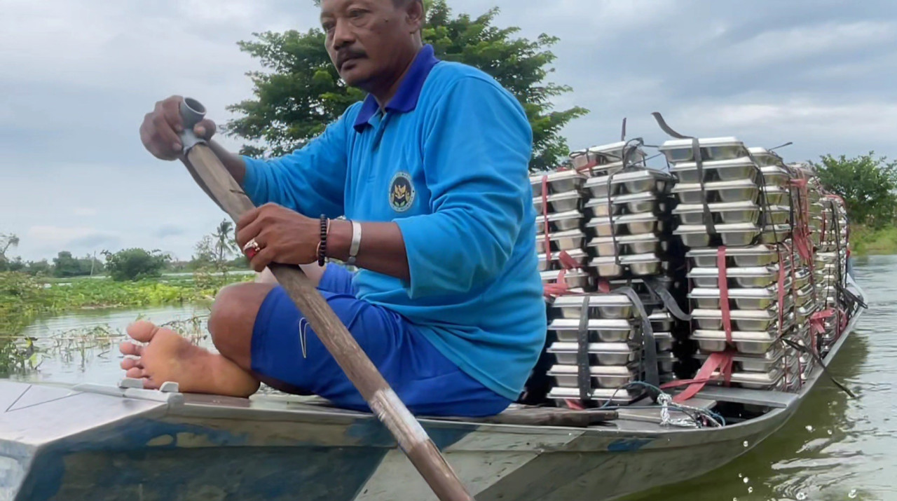 Foto: Penyaluran program MBG di tengah banjir luapan Bengawan Jero Lamongan. (Adyad Ammy Iffansah/jatimnow.com)
