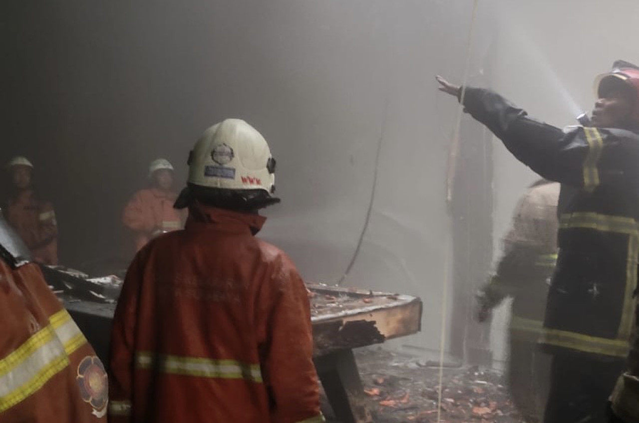 Foto: Petugas saat berusaha memadamkan kobaran api. (Fatkur/jatimnow.com)