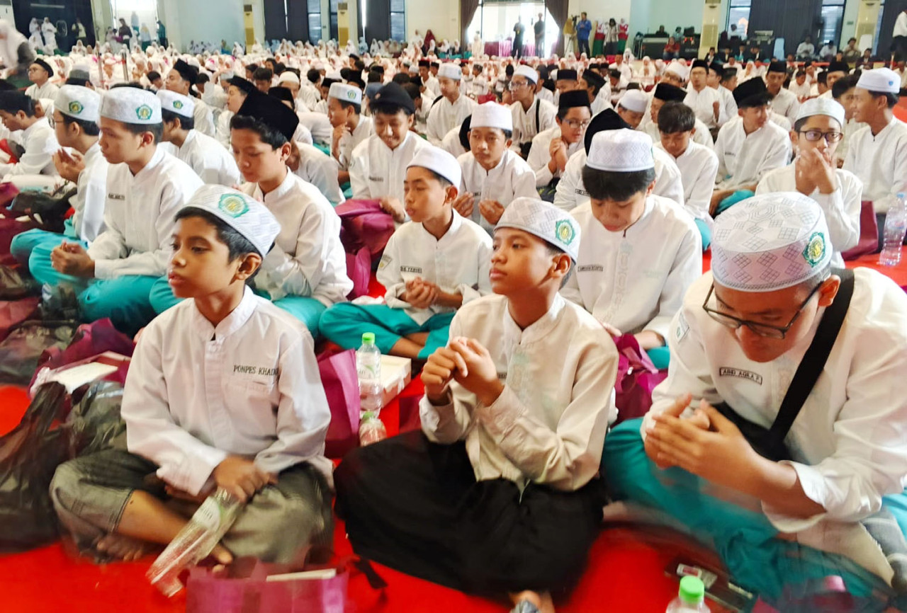 Ribuan santri dan pelajar Yayasan Khadijah khusyuk mengikuti rangkaian doa Haul ke-31 KH Abdul Wahab Turcham di Islamic Centre Surabaya, Minggu (25/1/2026), mengenang keteladanan pendidik yang menjunjung disiplin dan kasih sayang tanpa kekerasan. (Foto: Ali Masduki/jatimnow.com)