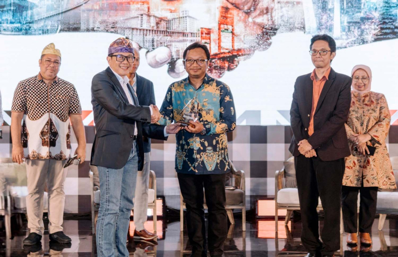 Direktur Sales dan Marketing SIG, Dicky Saelan (kiri) menyerahkan cendera mata kepada VP of Industry and Regional Research PT Bank Mandiri Tbk, Dendi Ramdani pada acara SIG Infrastructure Summit. (Foto: SIG/jatimnow.com)