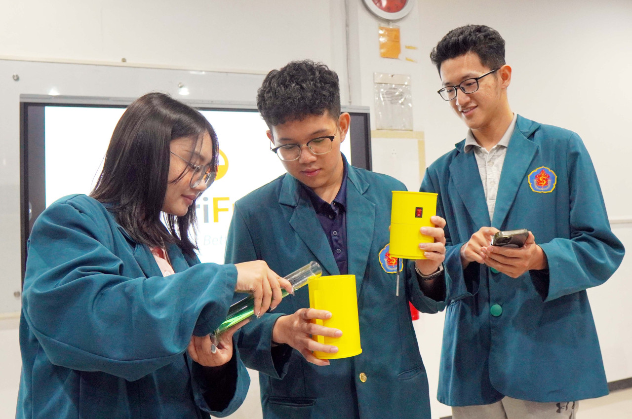 Christabel Audrey Theresya, Evan Nugroho, dan Michael Ong menunjukkan cara pengujian kemurnian BBM menggunakan VeriFuel. (Foto: Humas Ubaya/jatimnow.com)