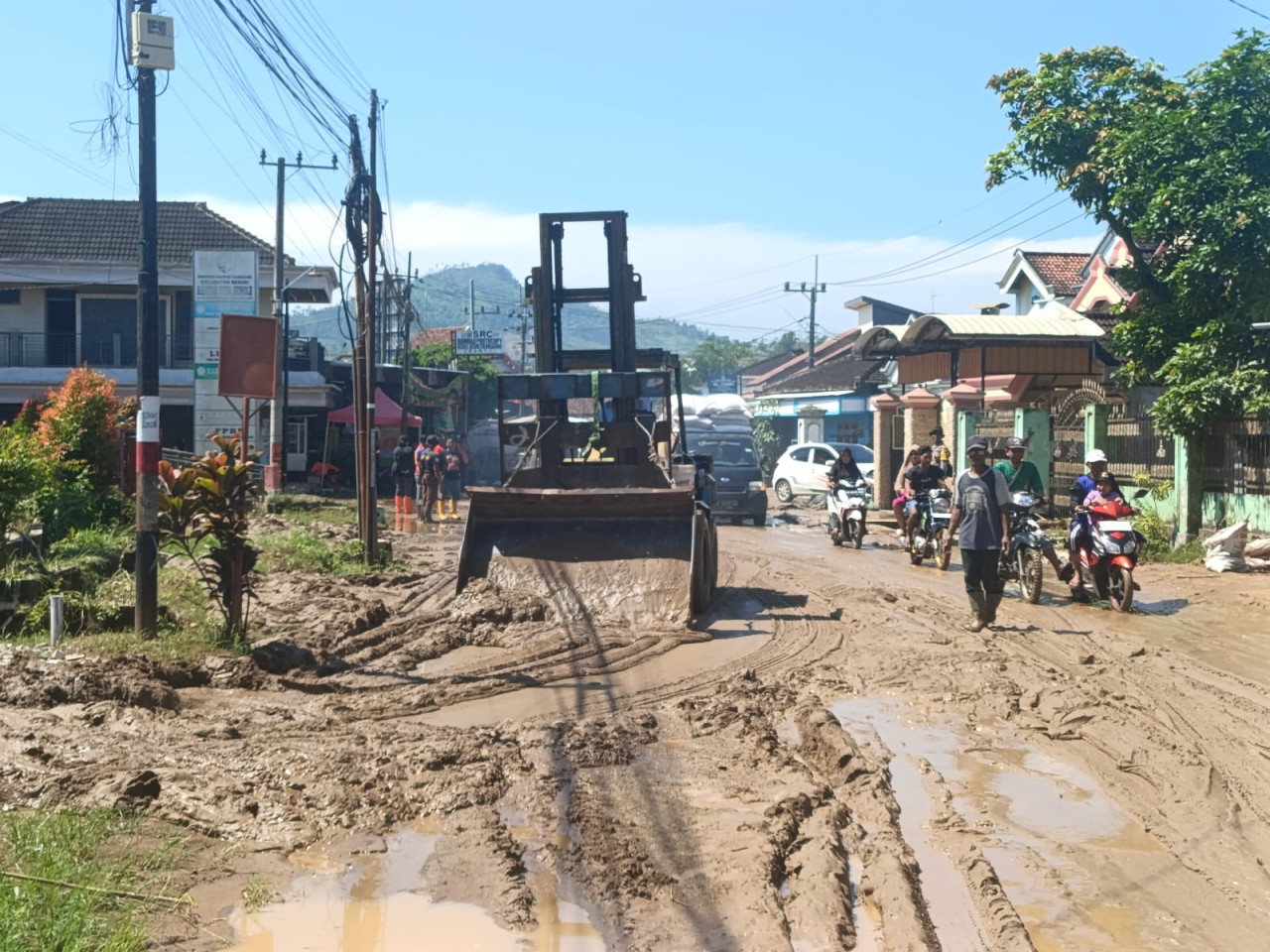 Foto: Petugas membersihkan lumpur dengan alat berat. (Bramanta/jatimnow.com)