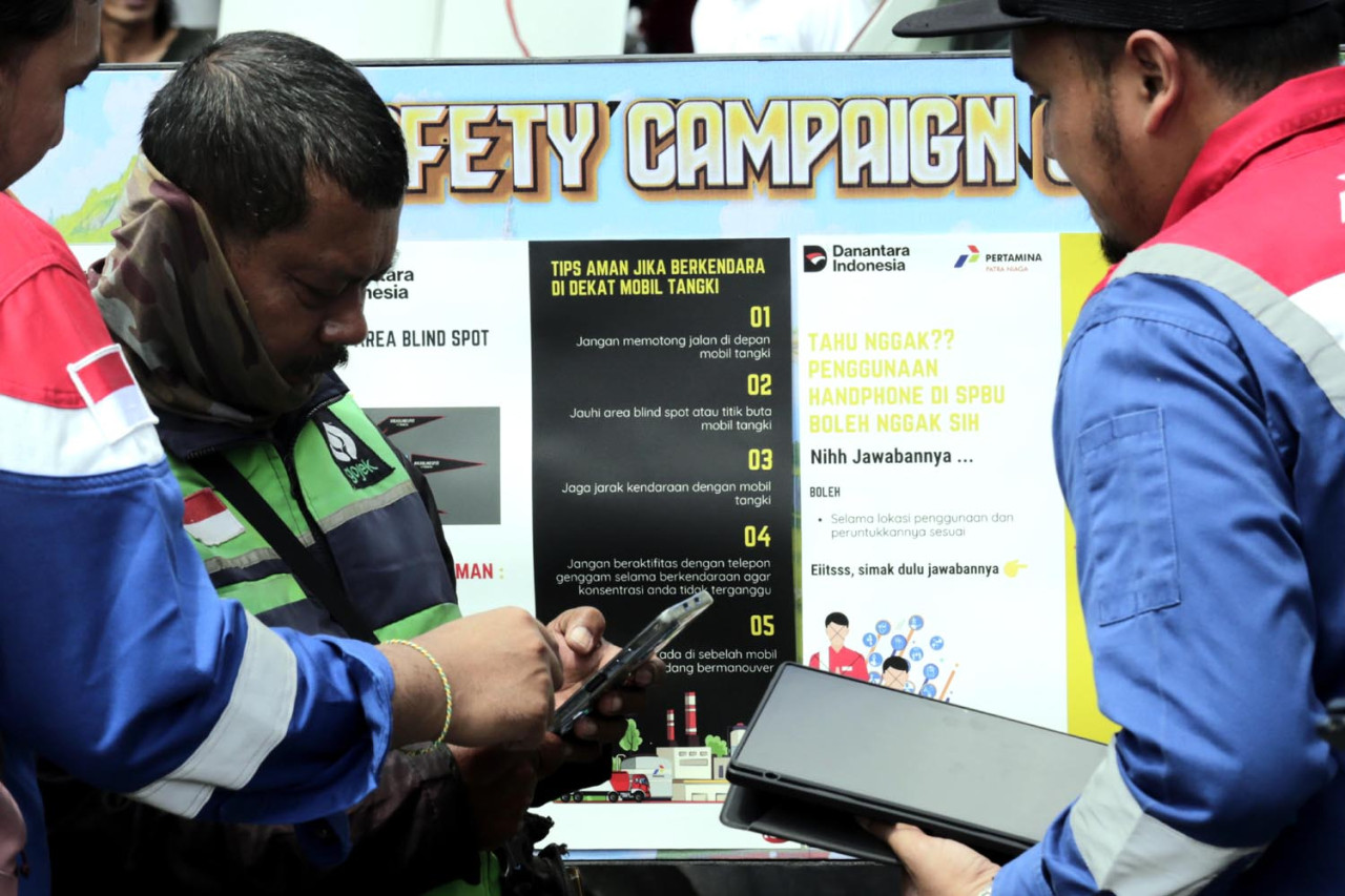 Petugas memandu pengemudi ojek online mengisi jawaban ketika mengikuti kuis Keselamatan dan Kesehatan Kerja (K3) di SPBU Coco Jemursari, Surabaya, Kamis (05/2/2026). (Foto: Ali Masduki/jatimnow.com)