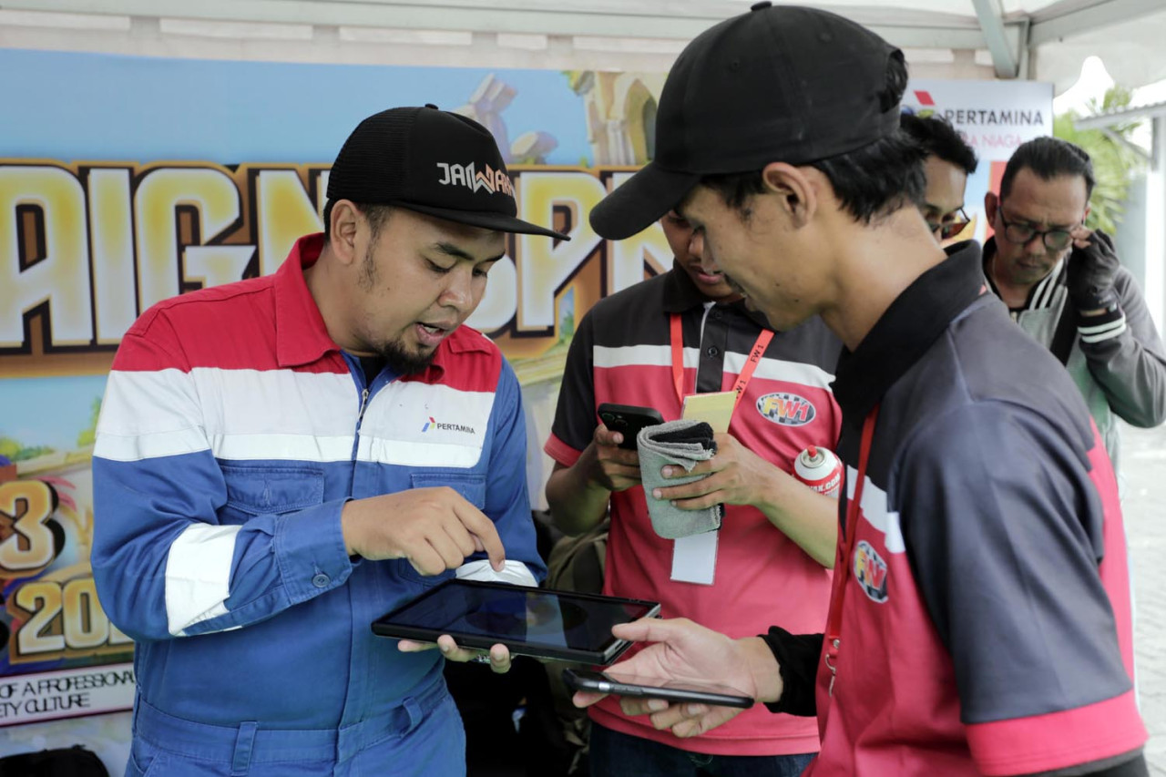 Petugas memandu pengendara ketika mengikuti kuis Keselamatan dan Kesehatan Kerja (K3) di SPBU Coco Jemursari, Surabaya, Kamis (05/2/2026). Momen bulan K3 Nasional 2026 dimanfaatkan tim Pertamina Patra Niaga Regional Jatimbalinus untuk menyapa langsung konsumen. (Foto: Ali Masduki/jatimnow.com)