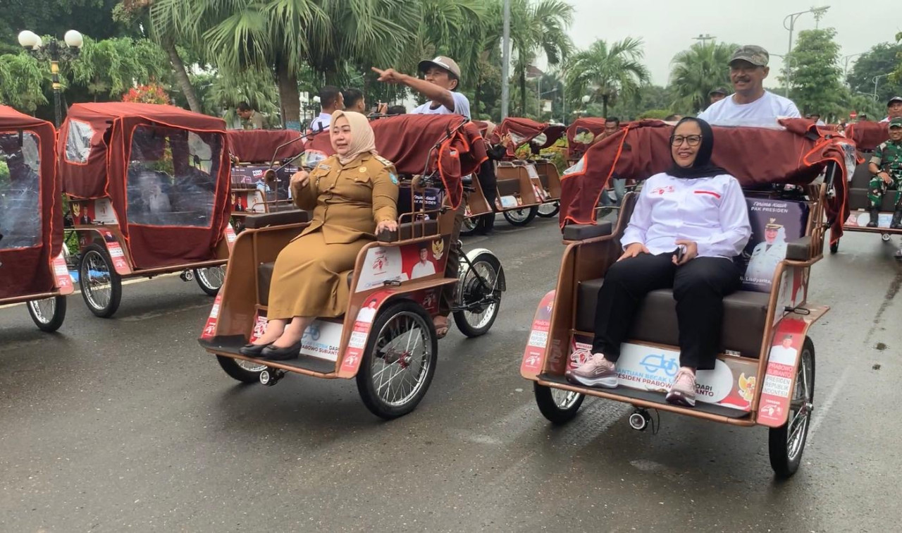 Tukang becak di Ponorogo tersenyum usai menerima bantuan becak listrik dari Presiden RI Prabowo Subianto. (Foto: Ahmad Fauzani/jatimnow.com)