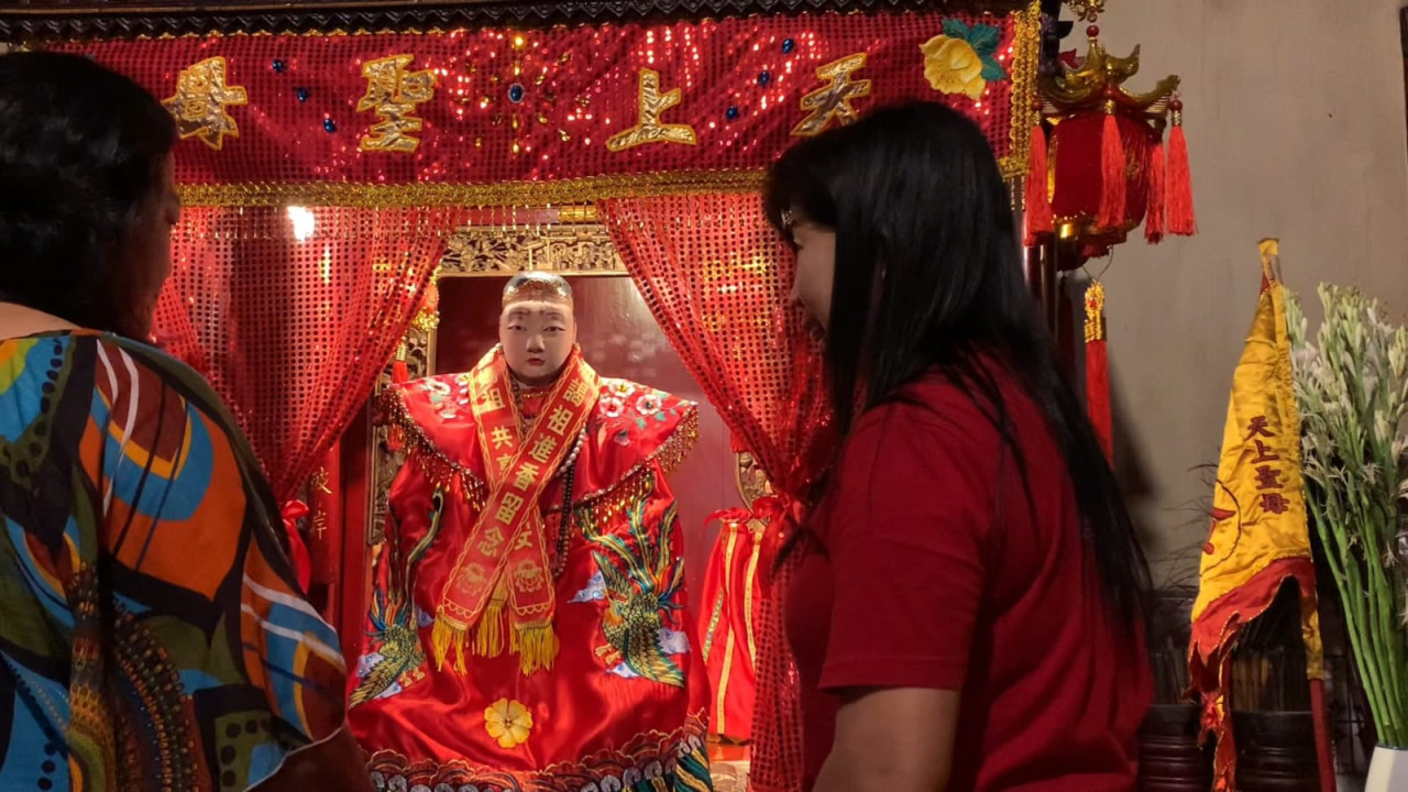 Foto: Pengurus mengganti baju Dewa Mak Co di Klenteng Tjoe Tik Kiong Tulungagung. (Bramanta/jatimnow.com)